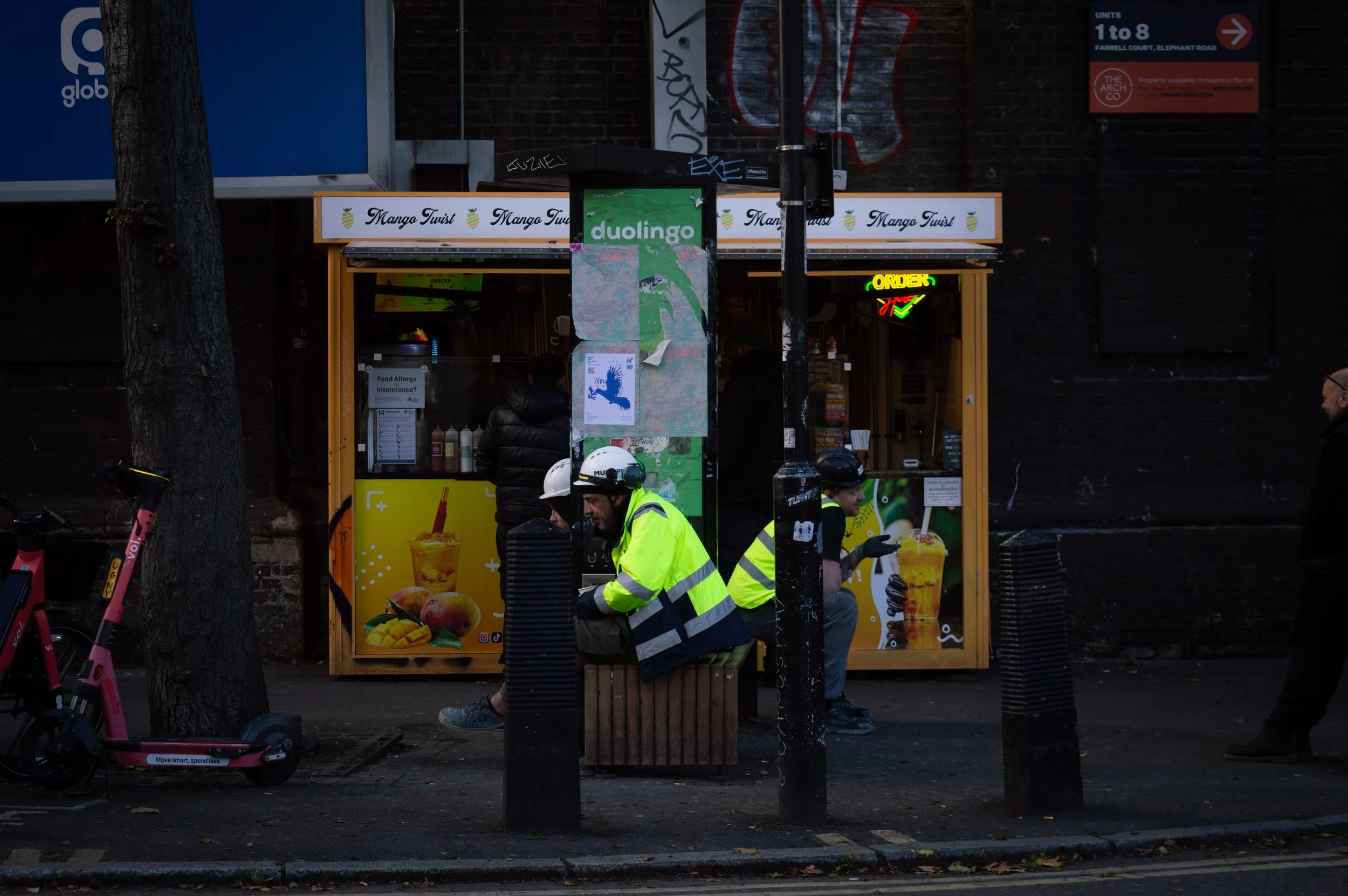 Southwark Council workers sitting outside of a stall eating lunch opposite Elephant and Castle park
