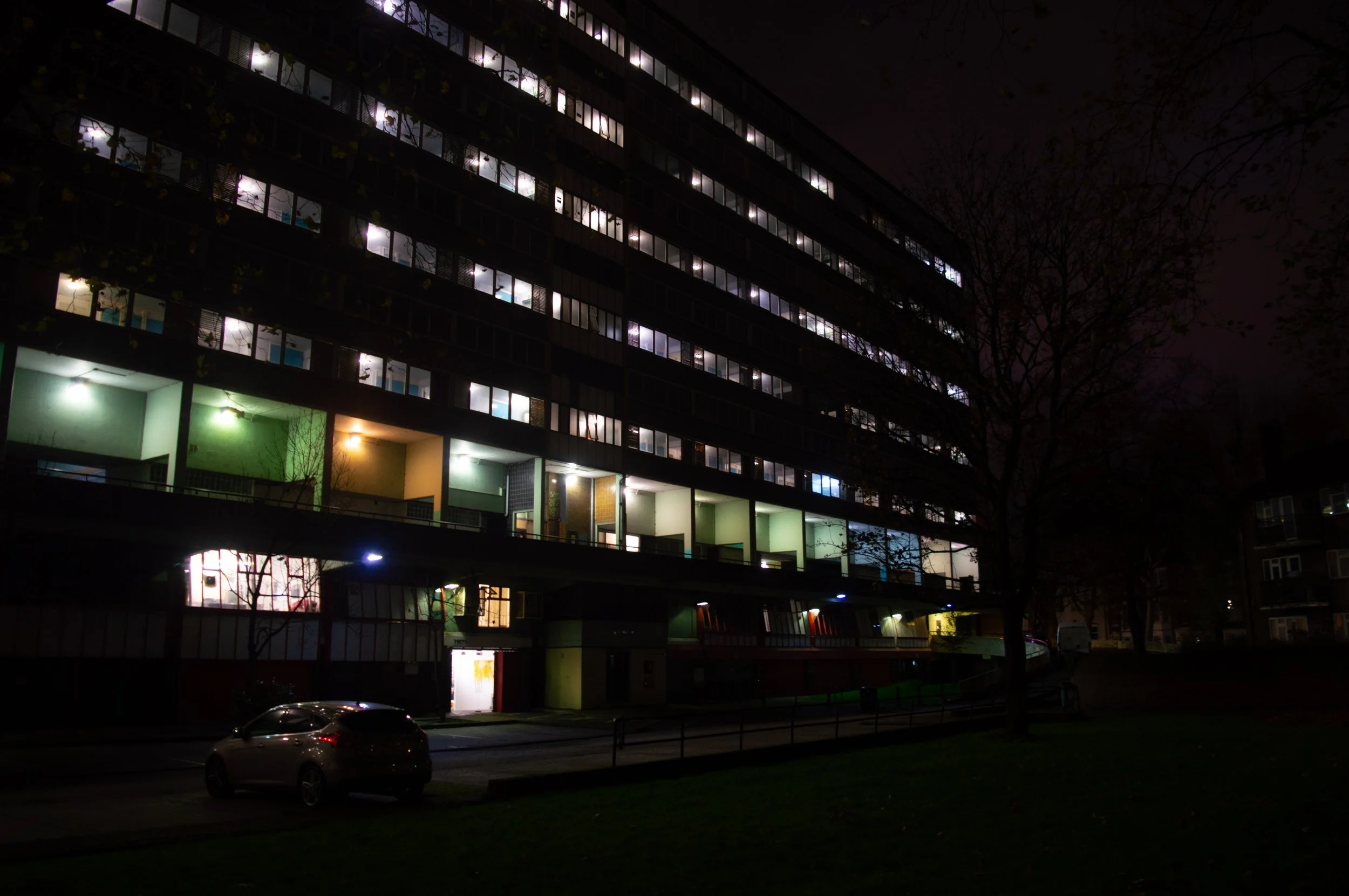a Aylesbury council estate block at night with bright colourful lights