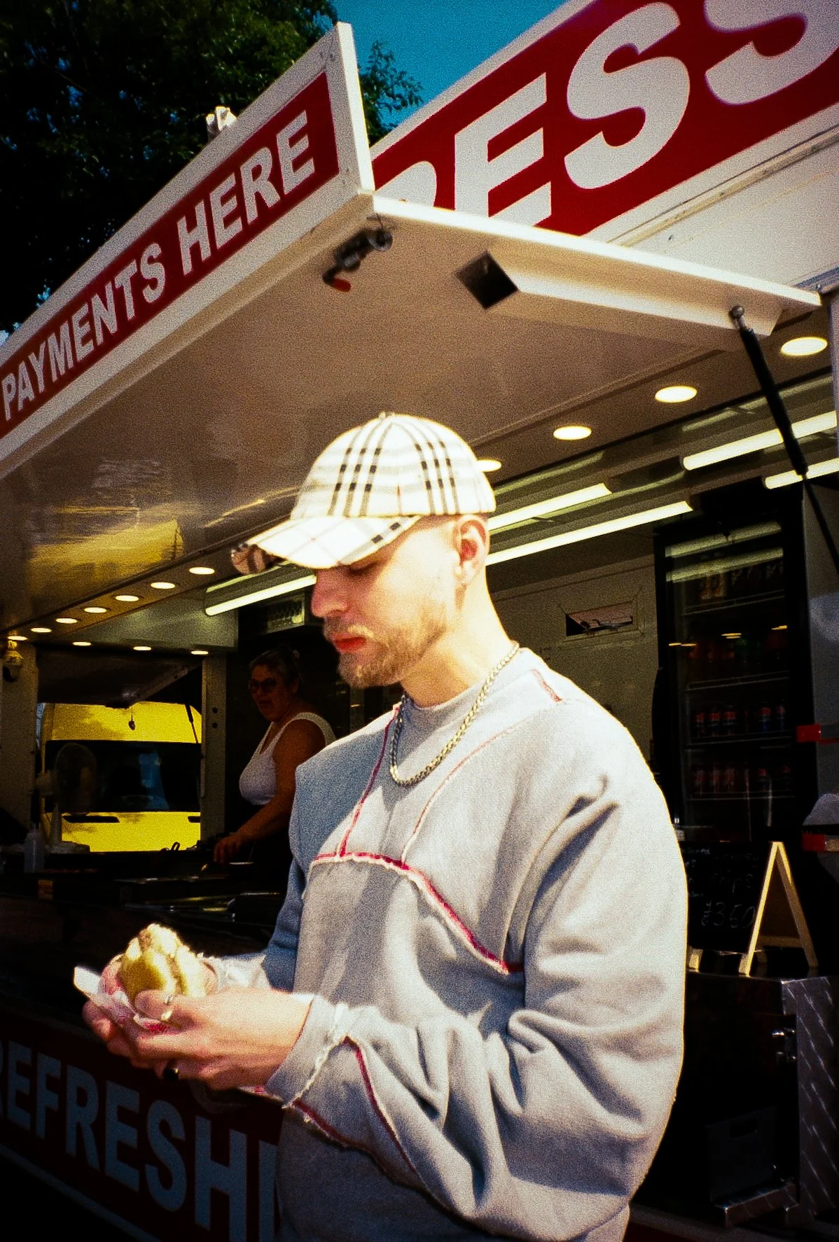 fashion model eating burger in front of burger van for street wear campaign