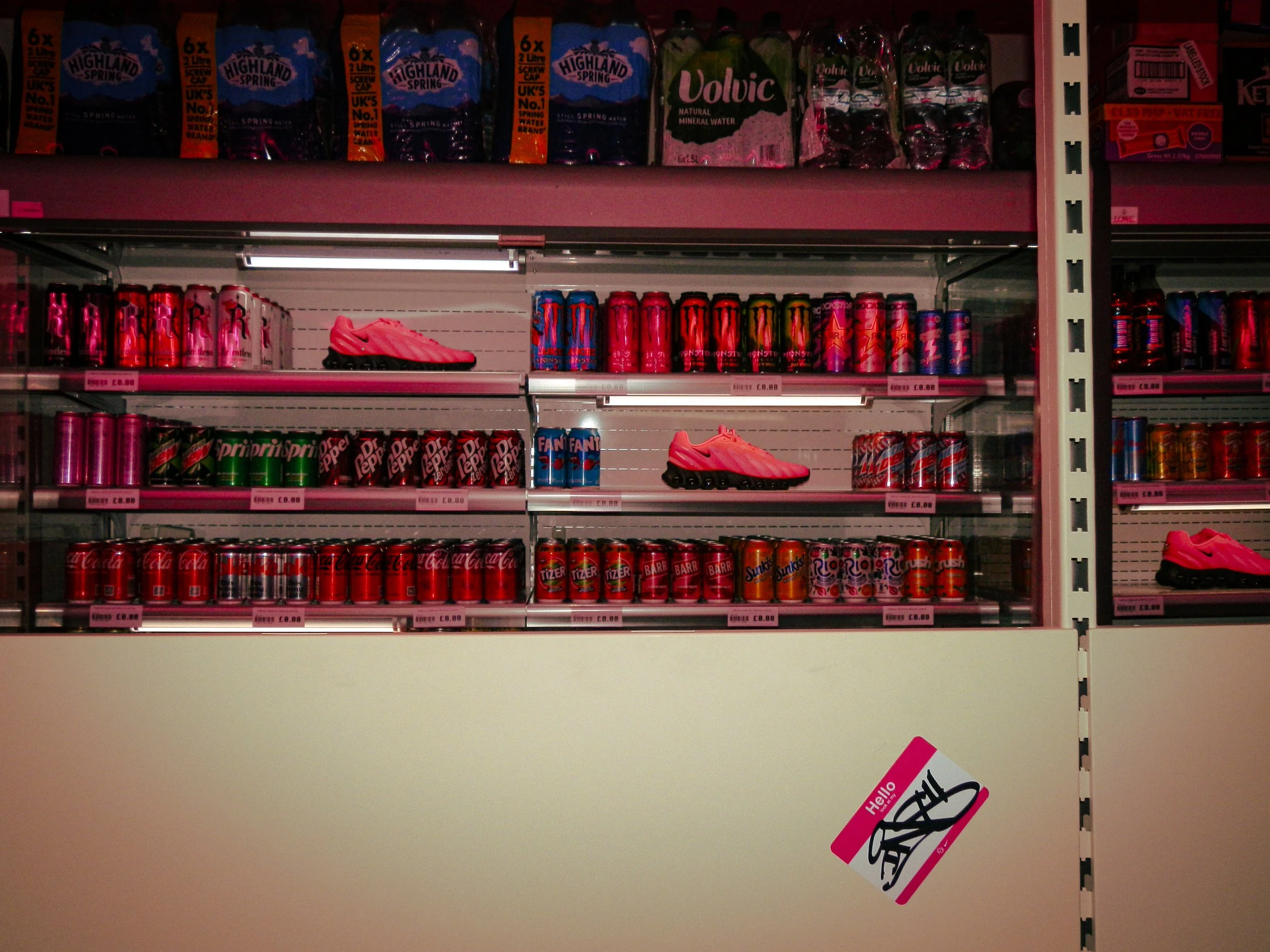 Nike trainers on corner shop style shelves with drink cans surrounding them 