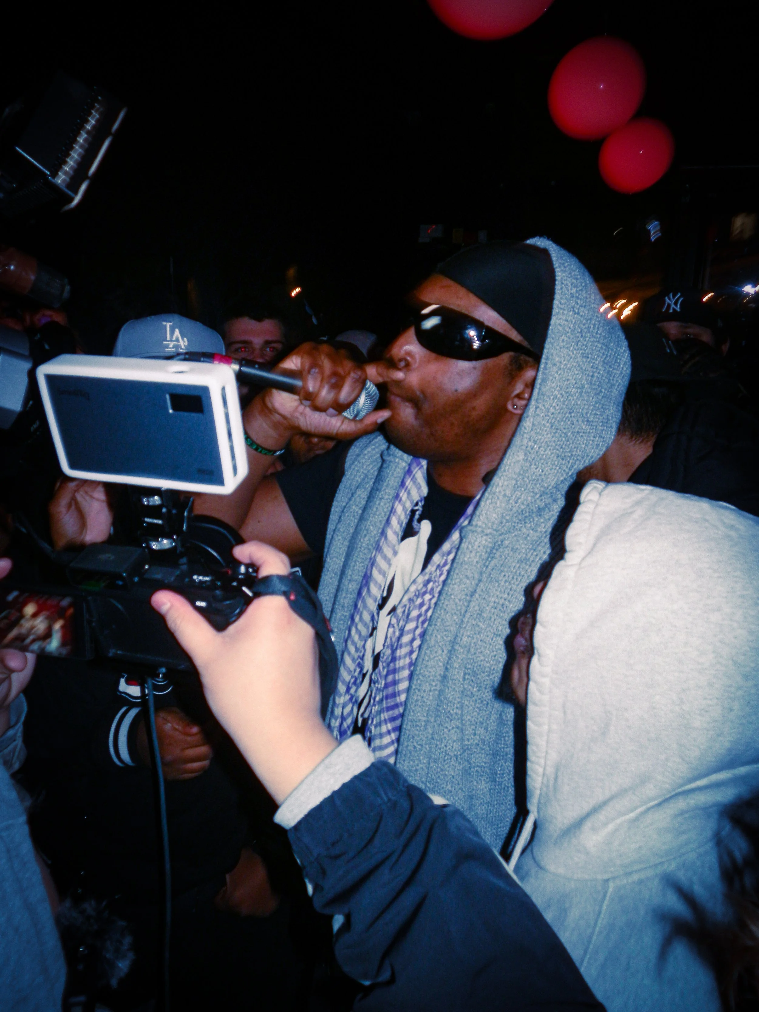 M.I.C performing at travspresents grime rave in the middle of a crowd with camcorders in his face