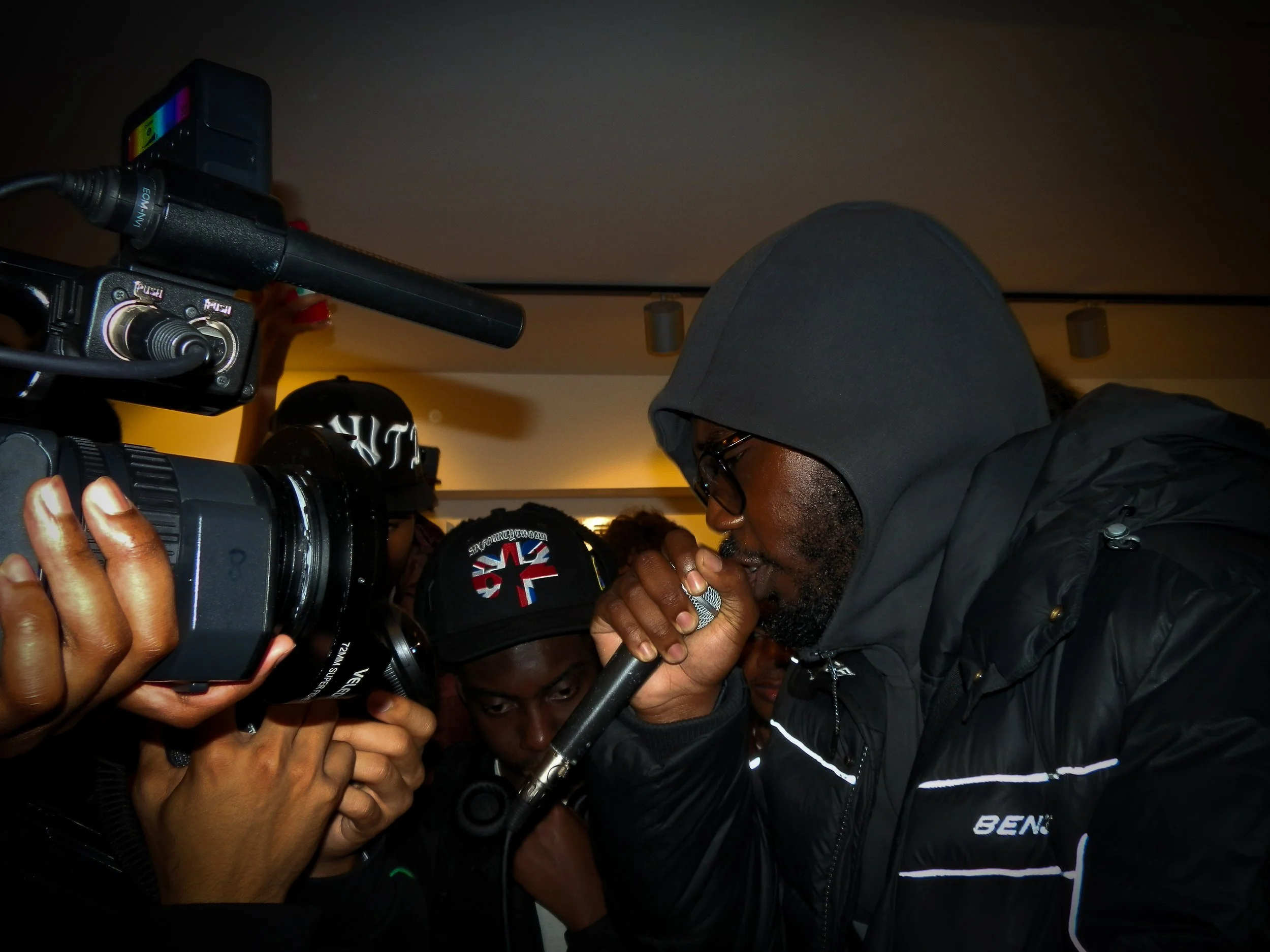 mc performing into a mic and cam corder at victory lap pop up cypher for simon Wheatley's don't call me urban book launch