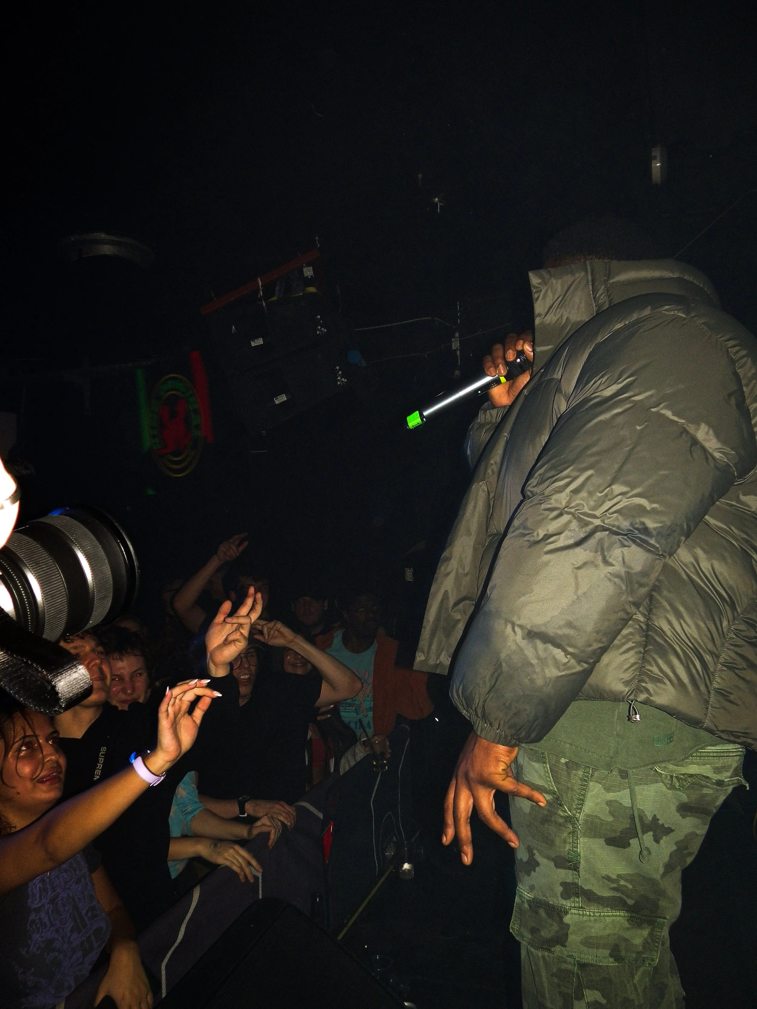 Kruz leone on stage mcing into microphone at grime rave in brixton