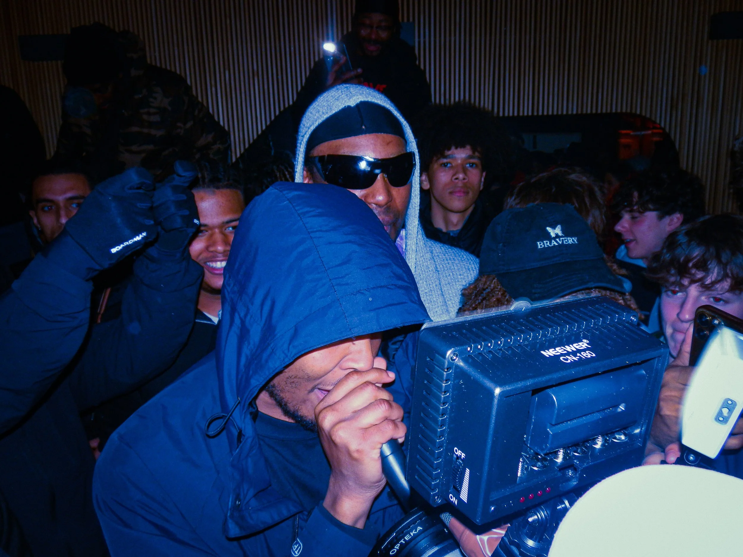 mercy ace performing at travspresents grime rave in the middle of a crowd with camcorders in his face