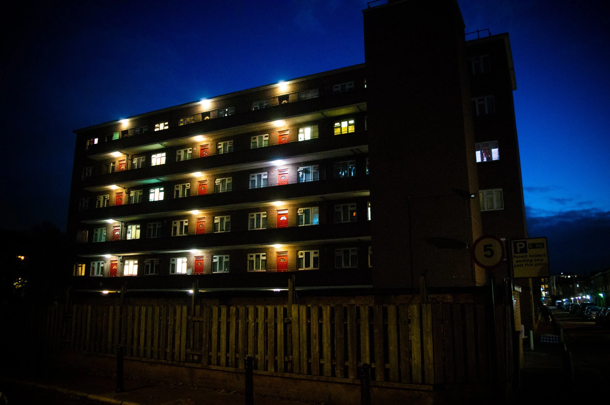 council estate with bright lights above the doors at night