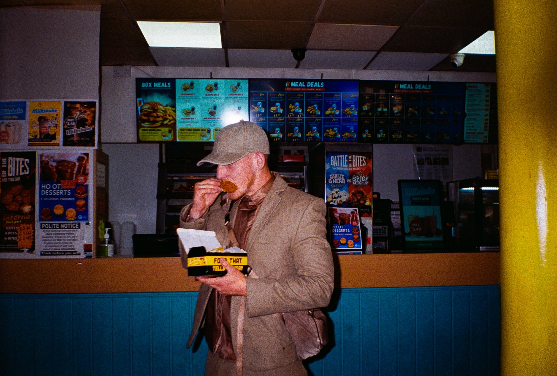 young man eating chicken and chips in chicken shop for Defends sportswear fashion campaign