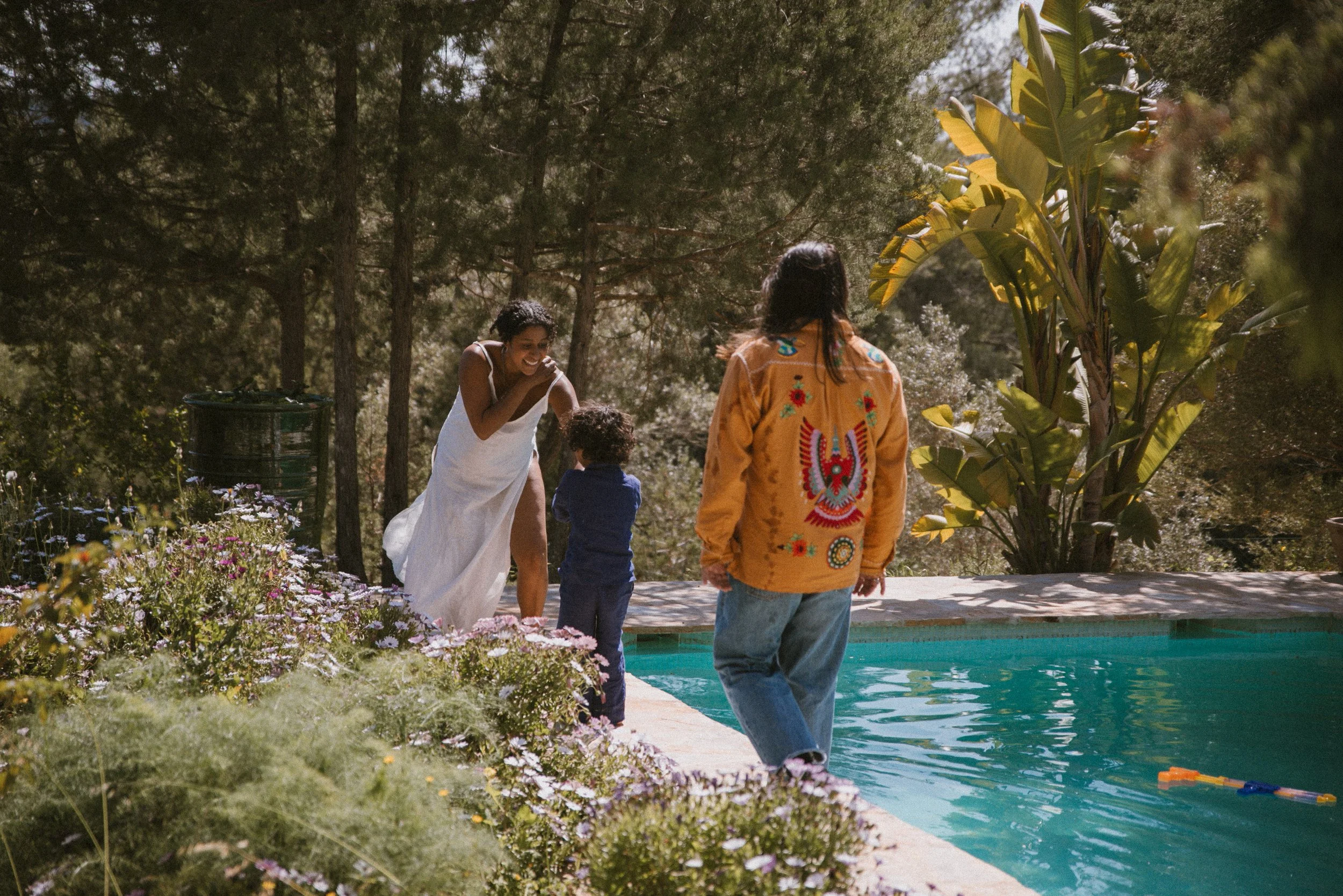 A table outdoors with various leftover plates of food, garlic bulbs, a small decorative gourd, and scattered autumn leaves after a meal, possibly during fall.