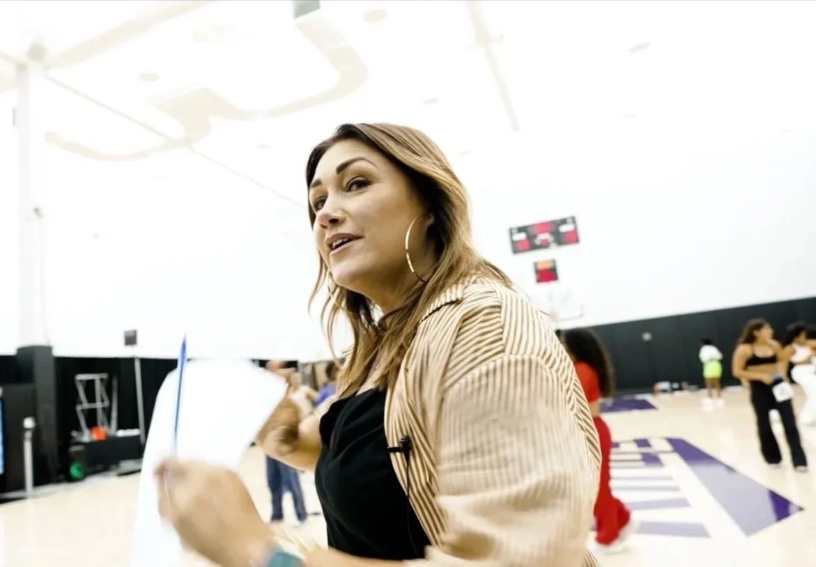 Sarah Schneeweis, NBA dance coach and choreographer directing dancers during rehearsal at a professional basketball arena