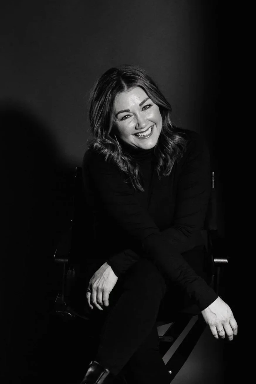 Sarah Schneeweis seated in a black top for a studio portrait