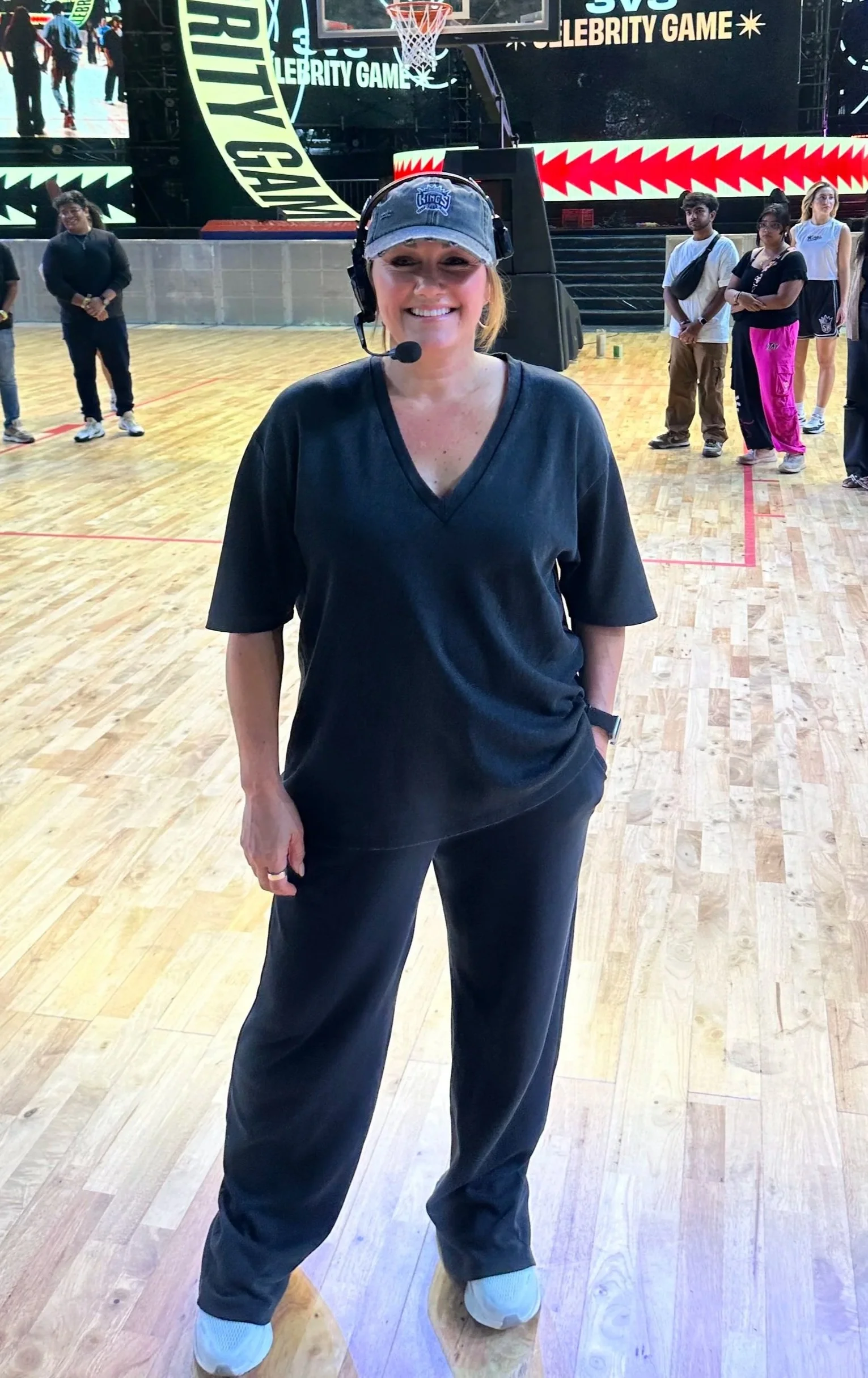 Sarah Schneeweis, NBA entertainment director and dance coach leading performers during live game production on a basketball court