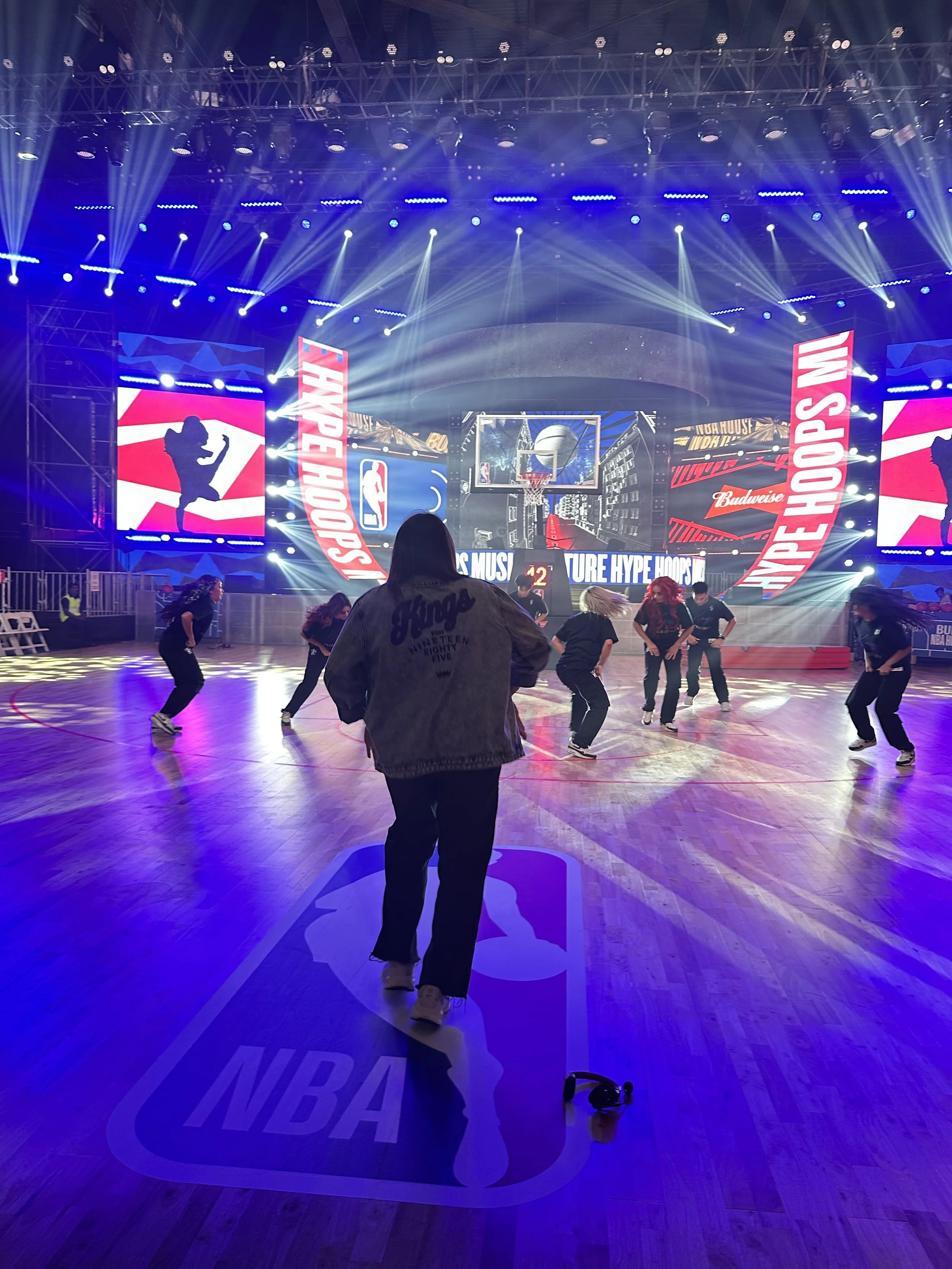 NBA dance team performance choreographed by Sarah Schneeweis during live game entertainment with professional dancers on court