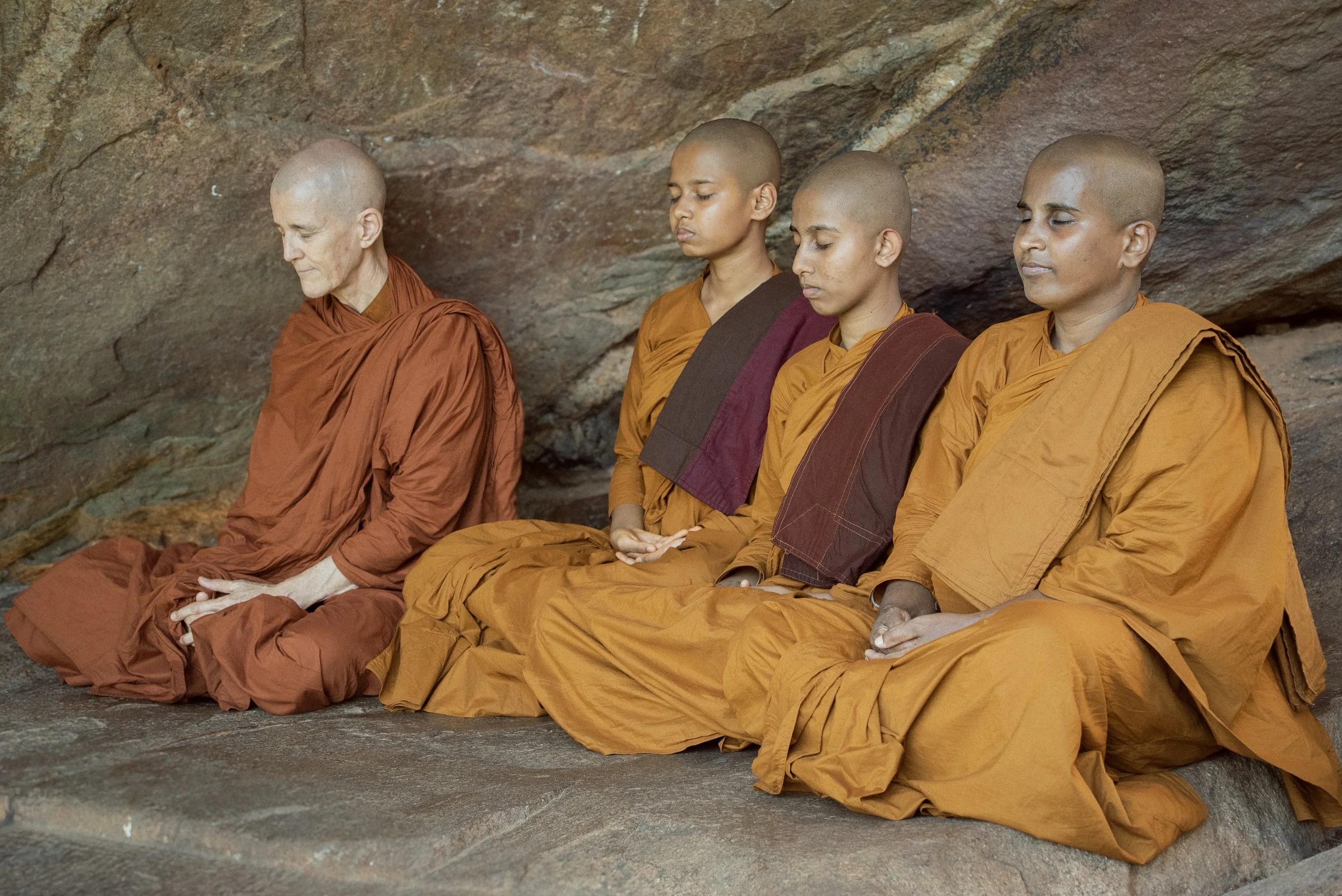 Bikkhuni and 3 Samaneris sitting eyes closed in a cave in Sri Lanka