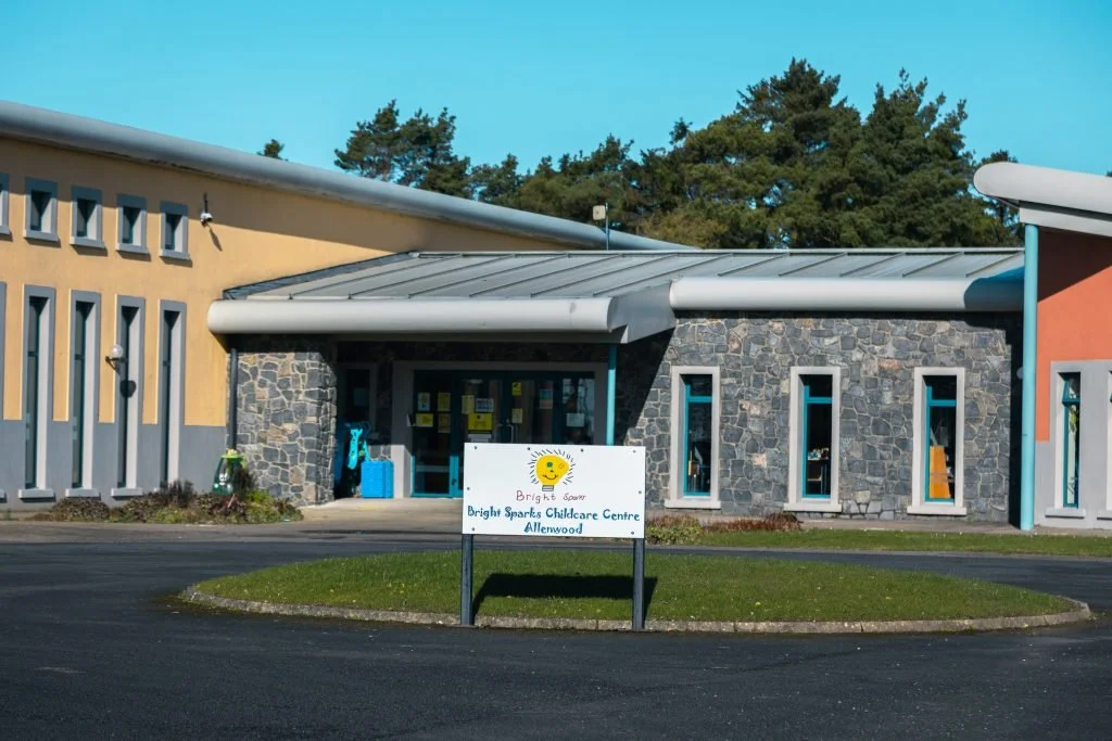 Front view of Bright Sparks Childcare Centre in Allenwood with a sign, colorful building, and trees in the background.