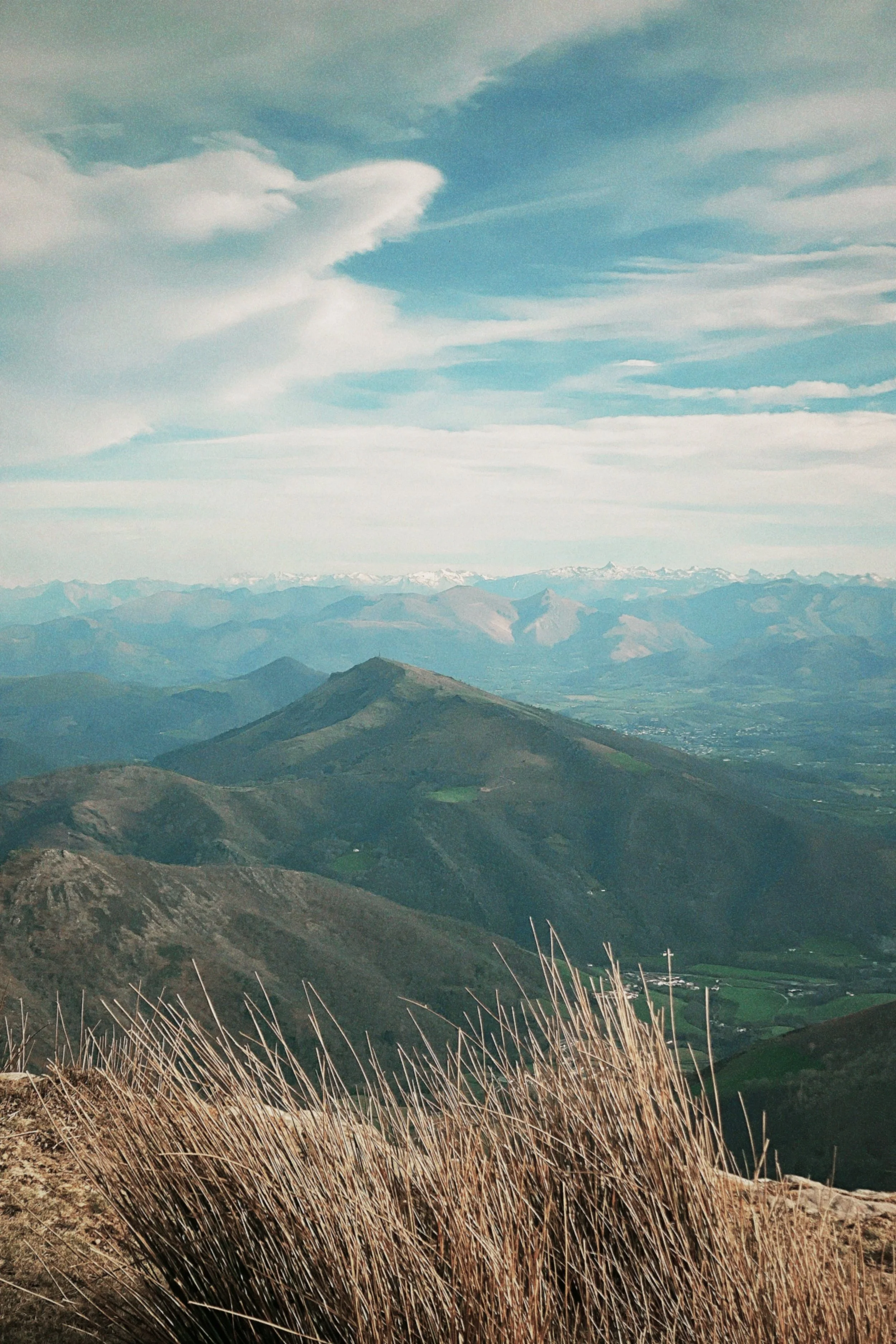 Paysage montagneux pays basque avec des sommets et un ciel partiellement nuageux.