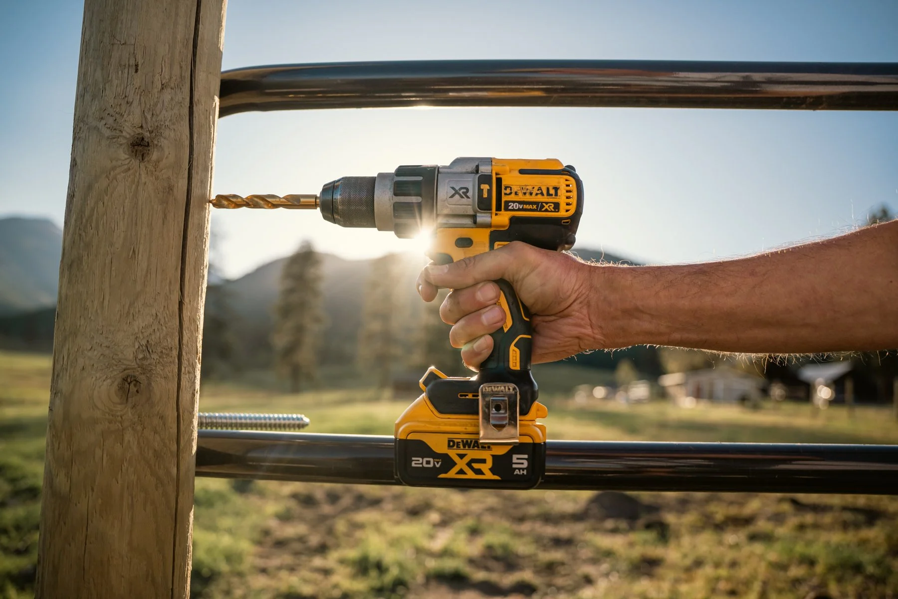 A person using a cordless DeWalt drill to drill into a wooden post outdoors during daylight.