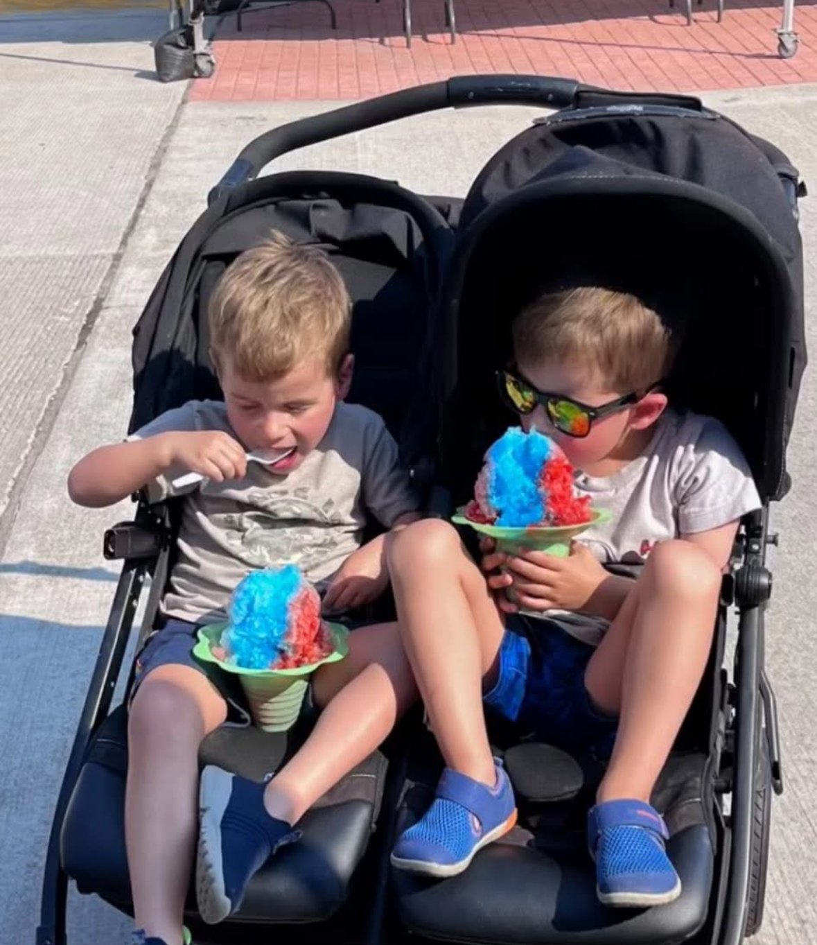 Children in a double stroller enjoying Sno Balls from Amaizeing Balls