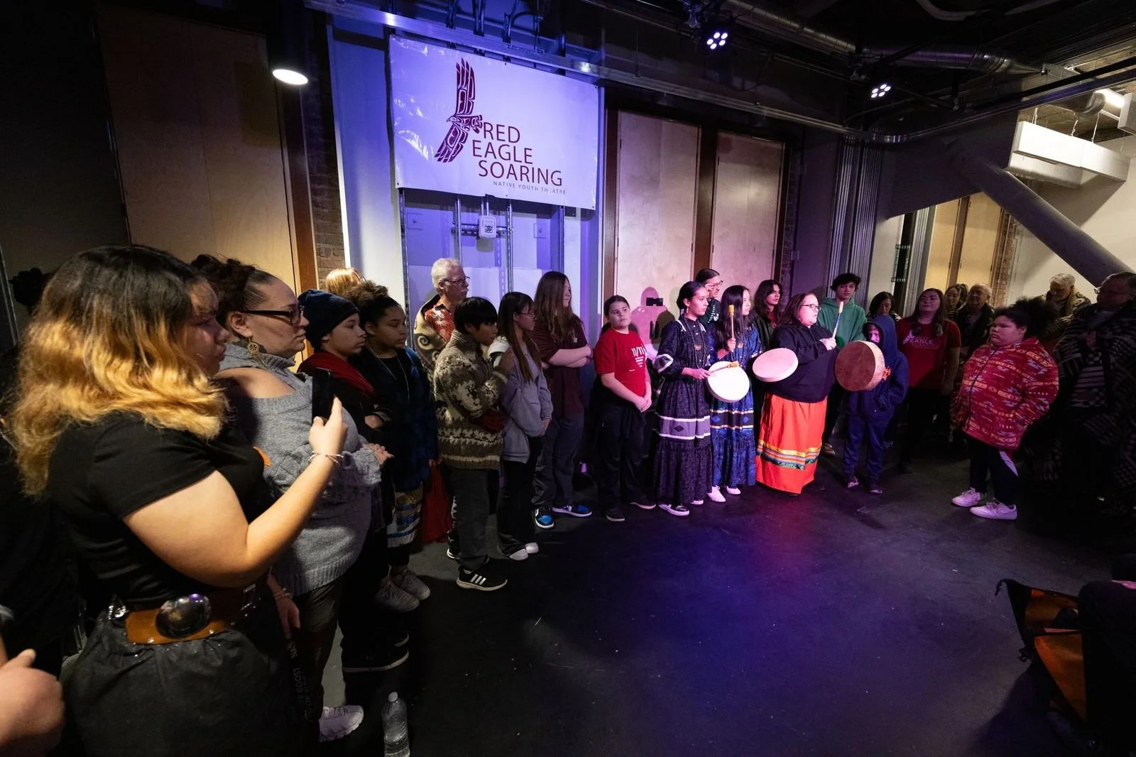 A group of youth and adults gathering under a sign that reads "Red Eagle Soaring."