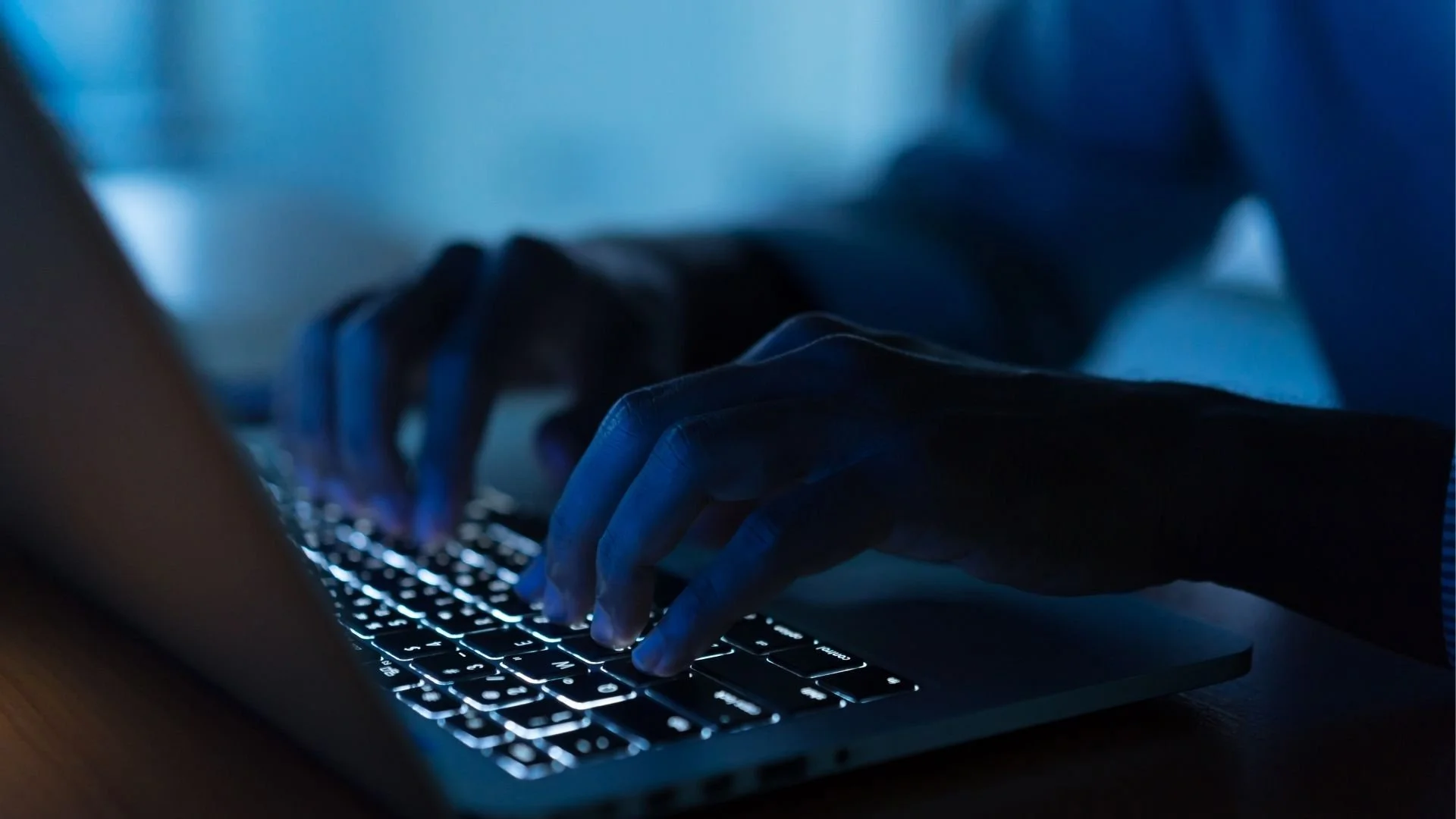 Close up picture of someone typing on a laptop