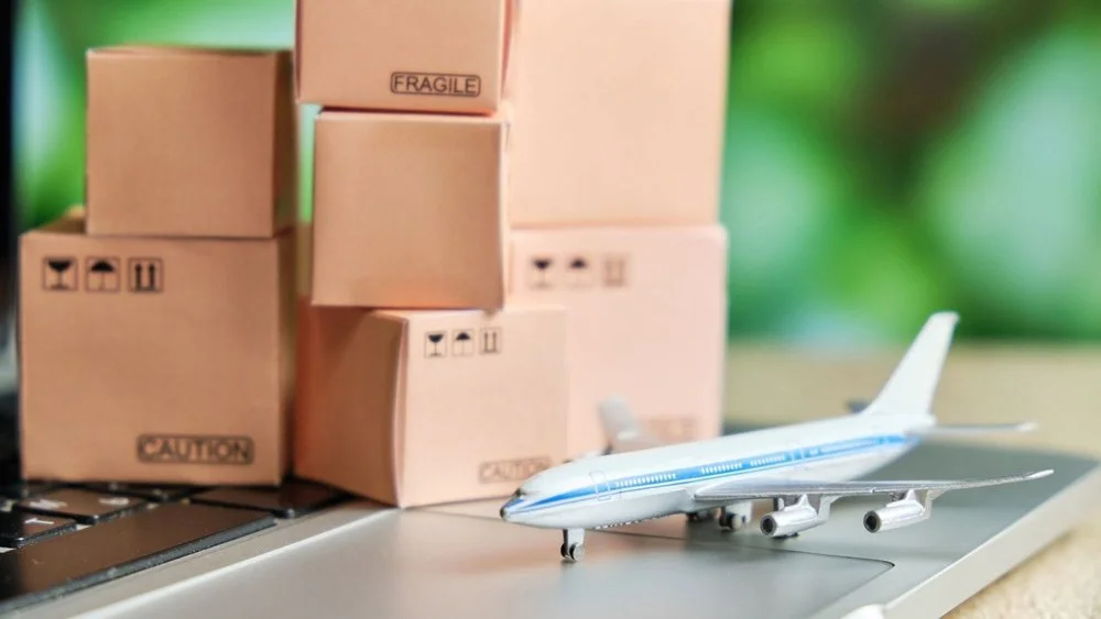 Small boxes and model passenger plane on laptop keyboard
