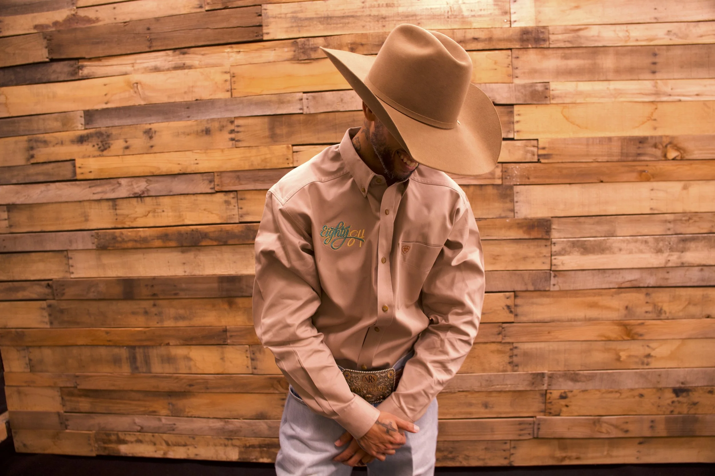 Clinician wearing a cowboy hat and embroidered shirt, photographed against a wooden backdrop in a relaxed portrait.