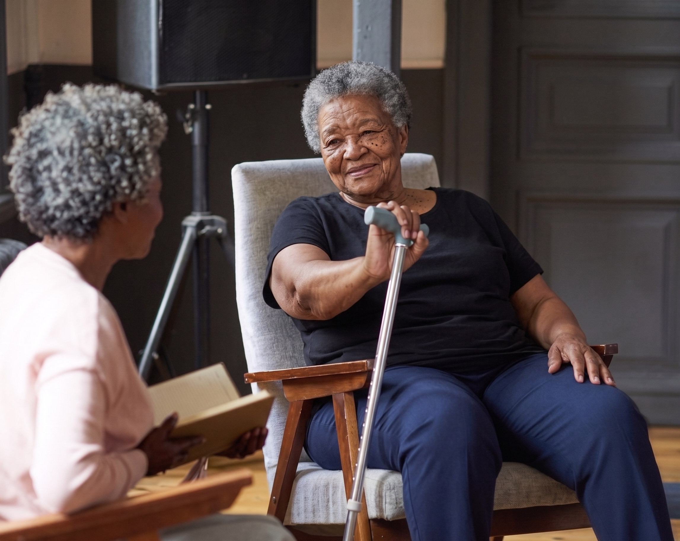 Senior woman with cane talking with caregiver during a home care visit.