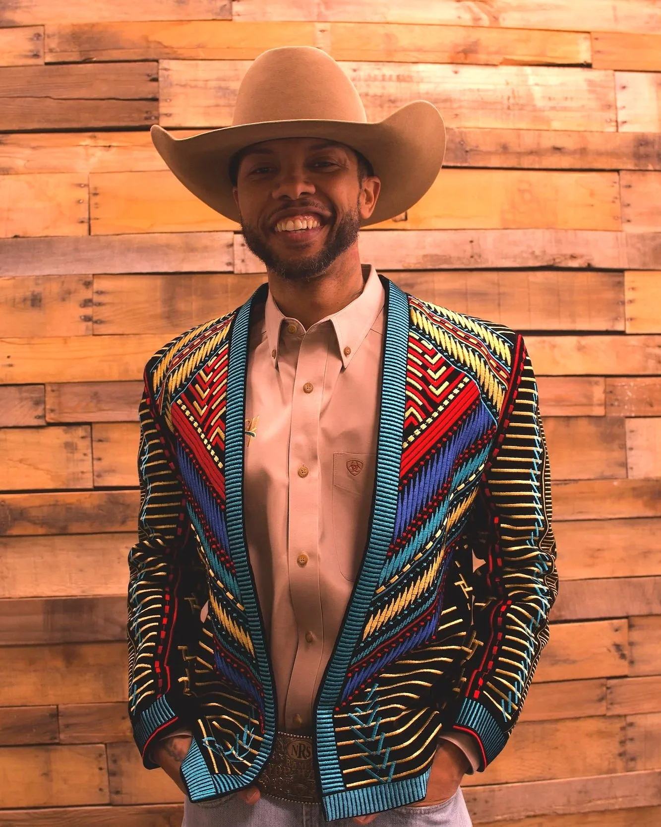 Clinician standing during a professional portrait against a wooden backdrop.