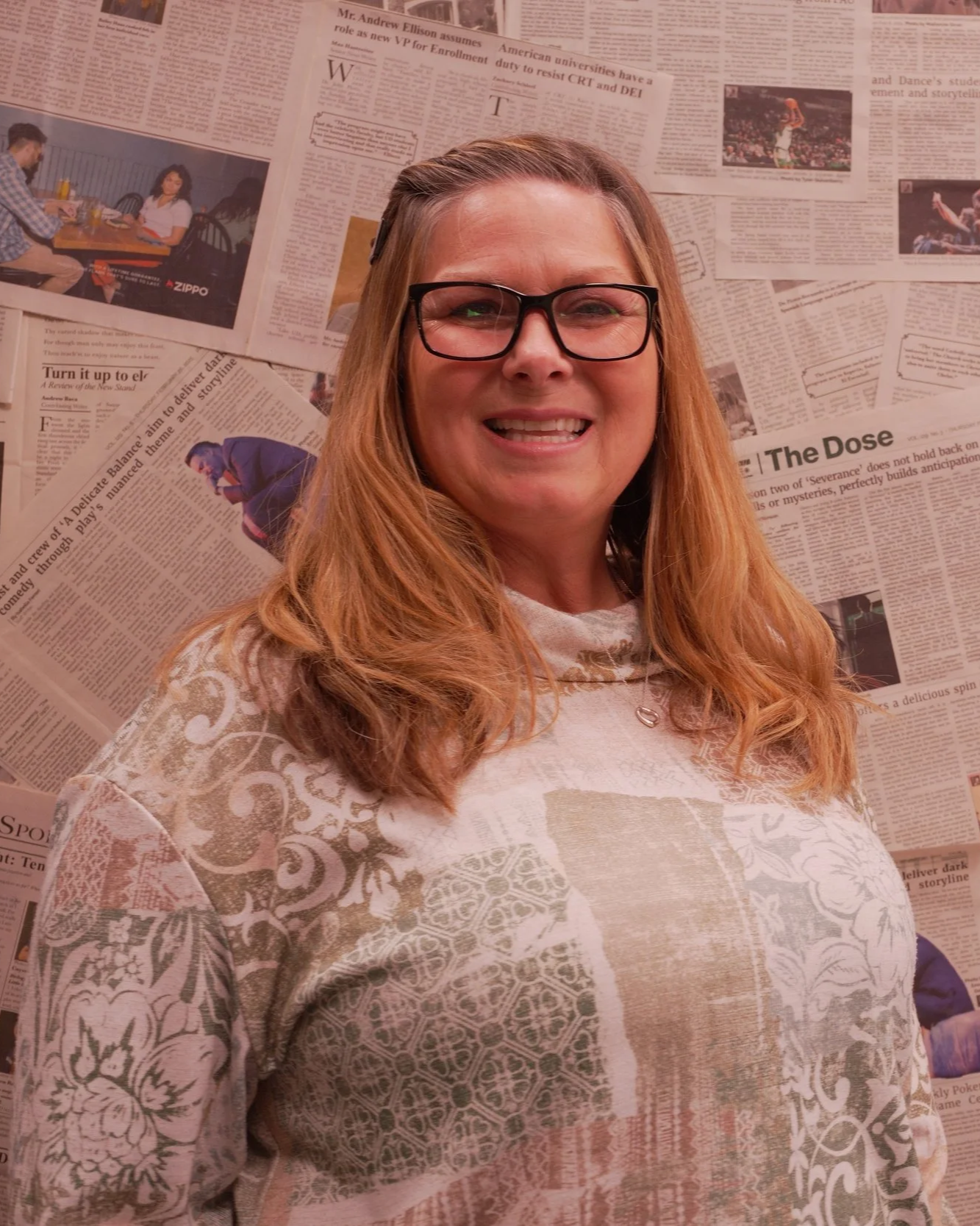 Clinician photographed during a professional portrait session against a newspaper backdrop.