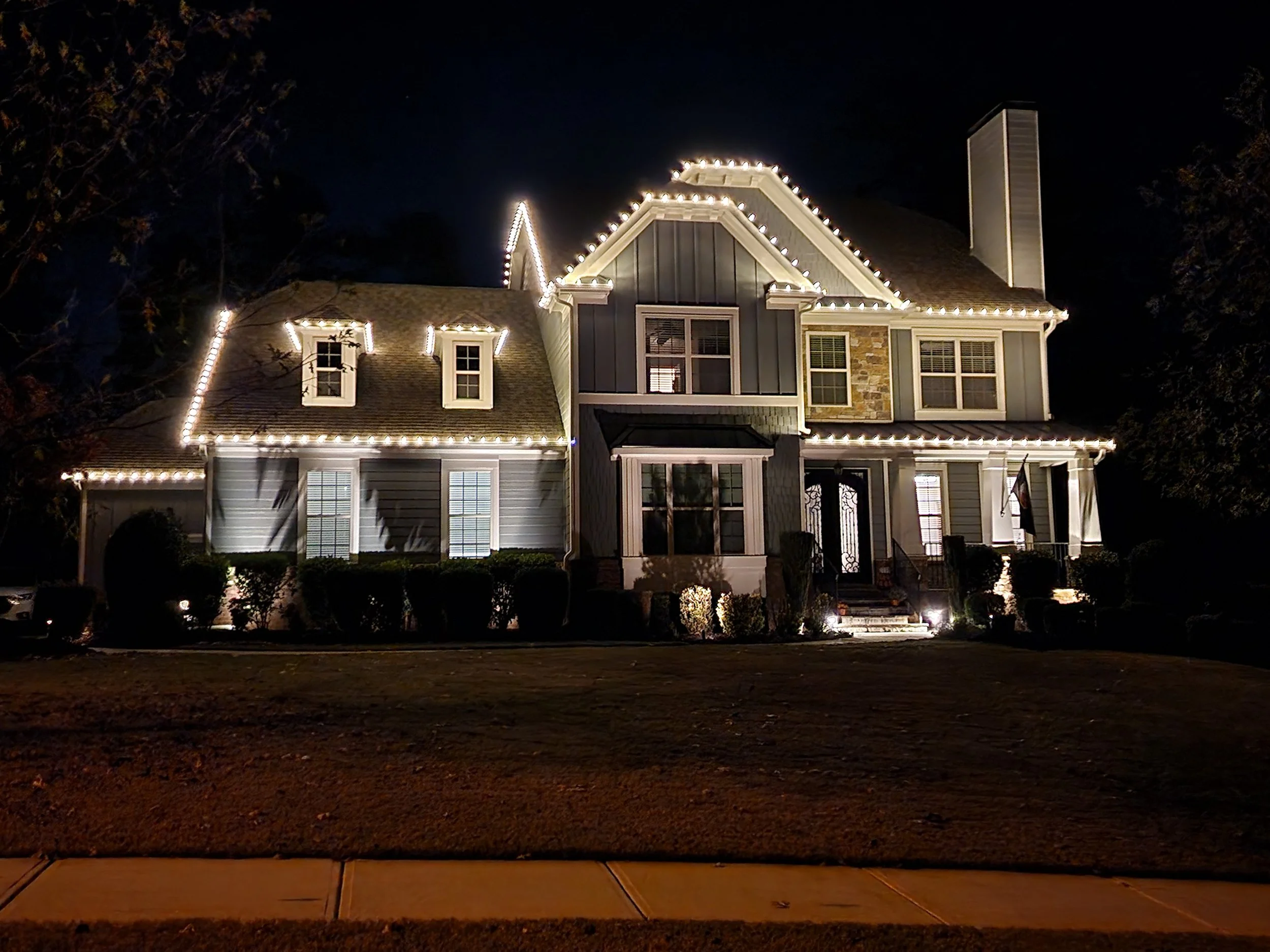 NW Metro Atlanta home with permanent LED trim lighting installed along the roofline, gables and dormers