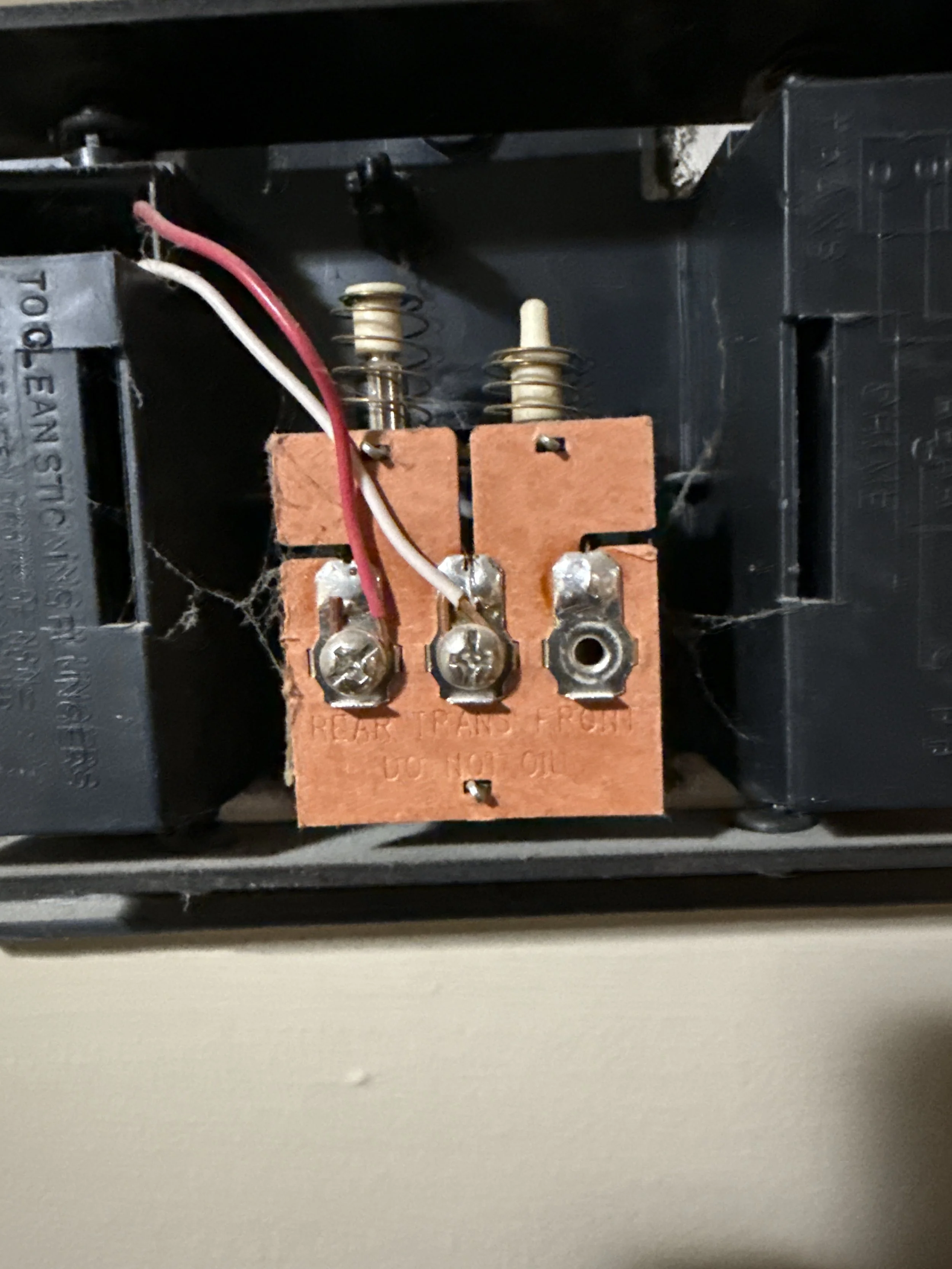 Close-up of an electrical component with three terminal screws, wires, and a copper relay coil inside a device.