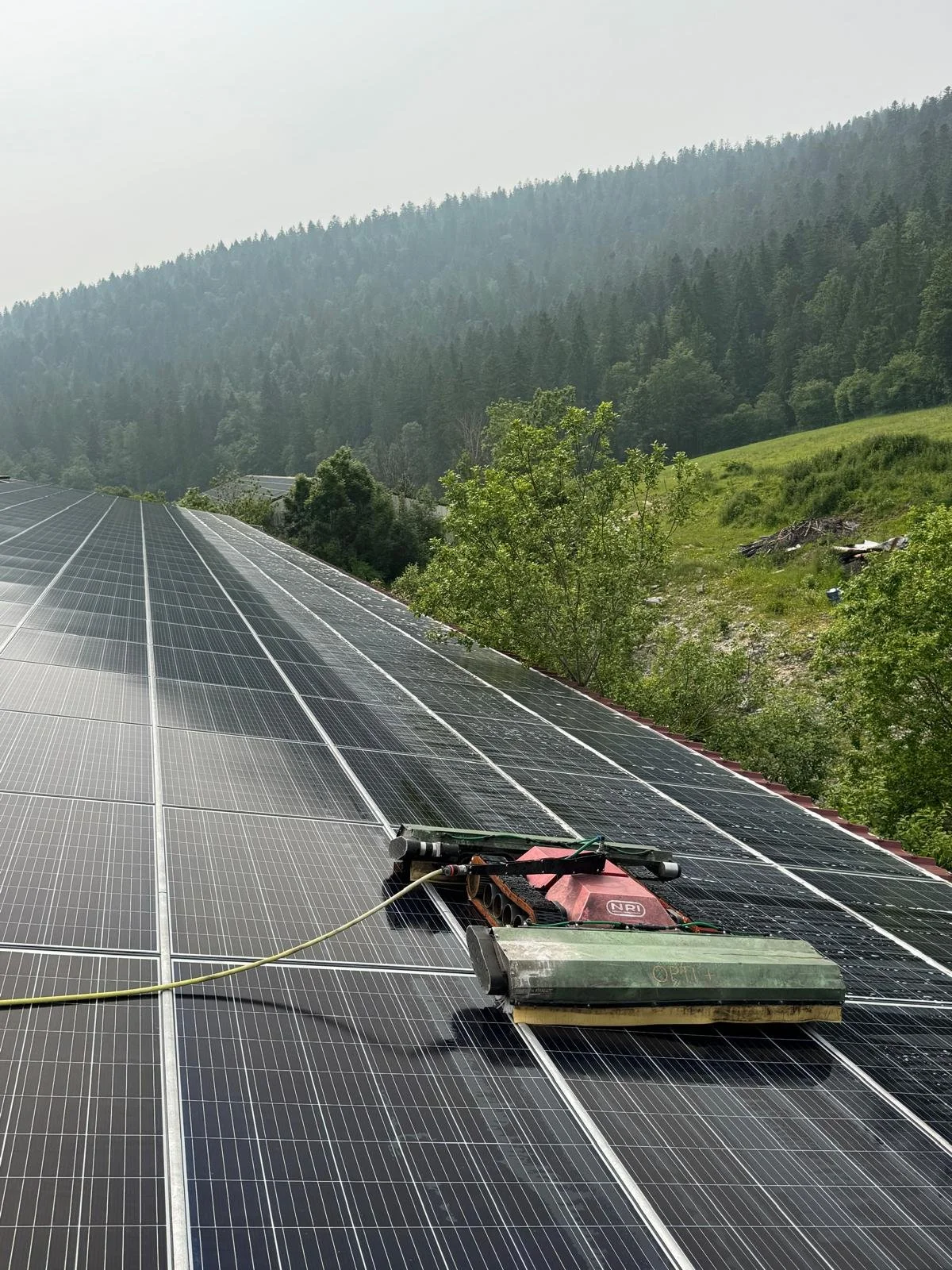 Panneaux solaires installés en plein air dans un environnement naturel de montagnes et de forêts.