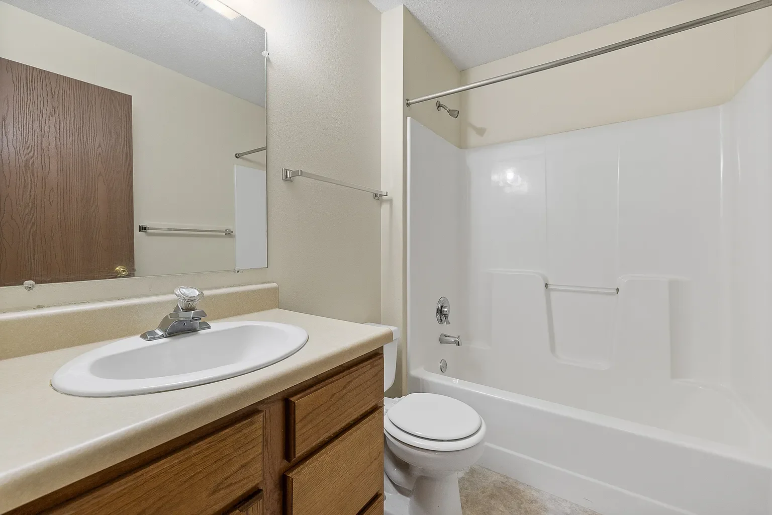 Bathroom with a vanity, sink, mirror, toilet, and bathtub with a shower.