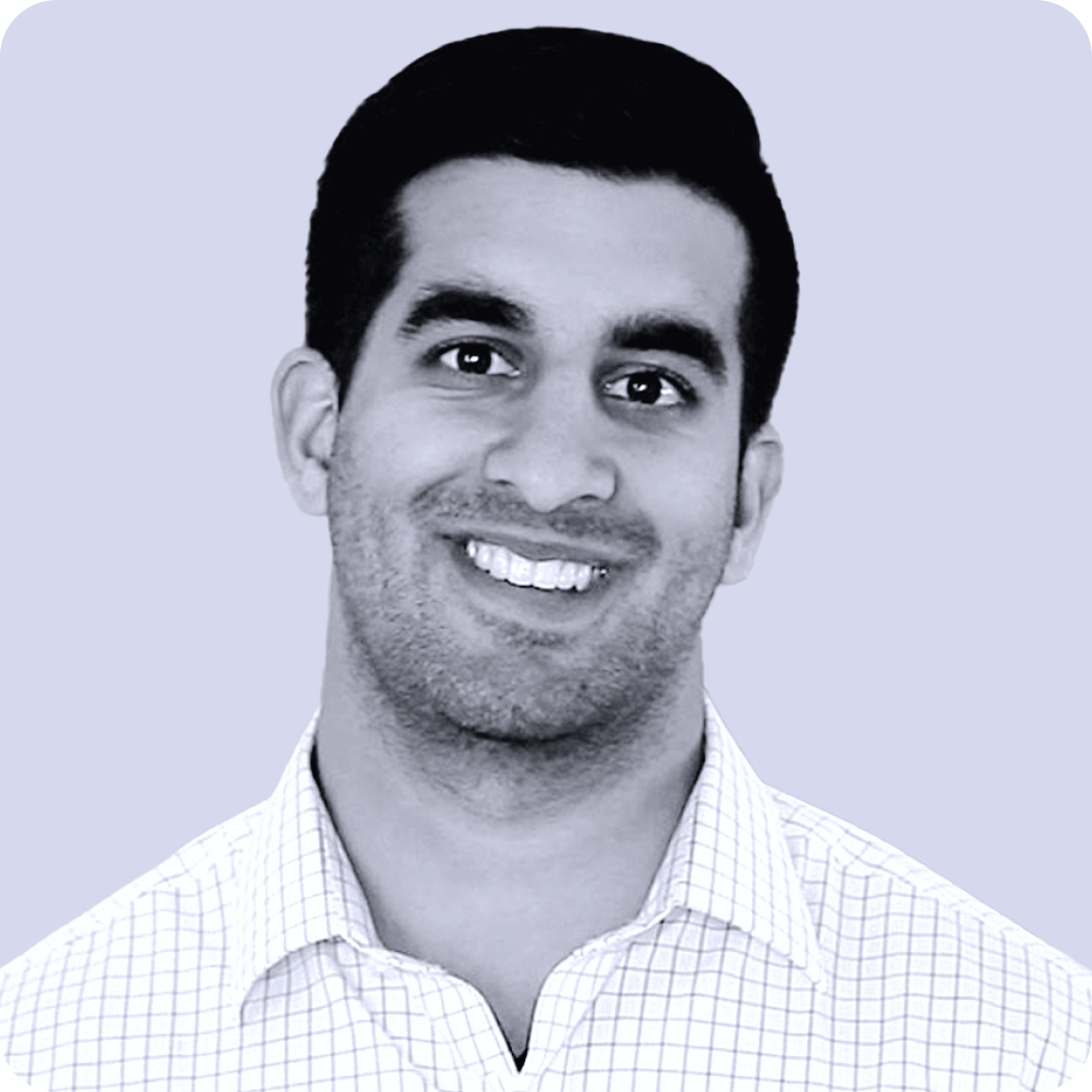 Raghav Tanna, Strategic Advisor of Rising Tide Insurance, headshot of a smiling man with short dark hair, wearing a checkered shirt against a plain light background.
