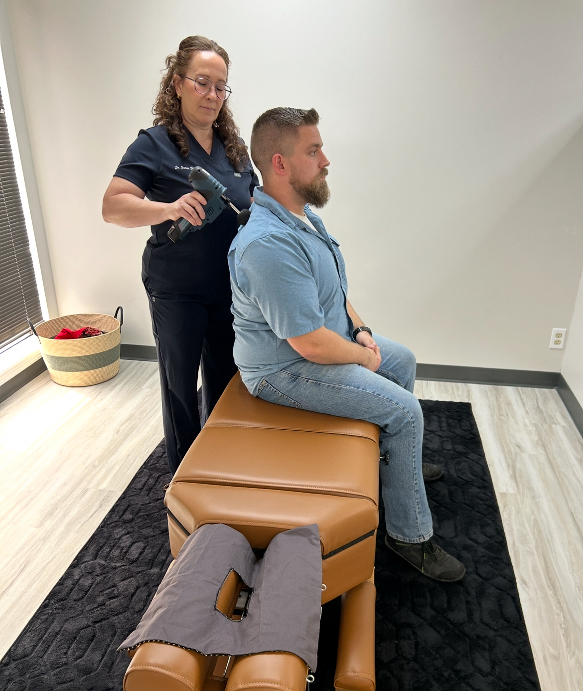chiropractor massaging man's shoulder