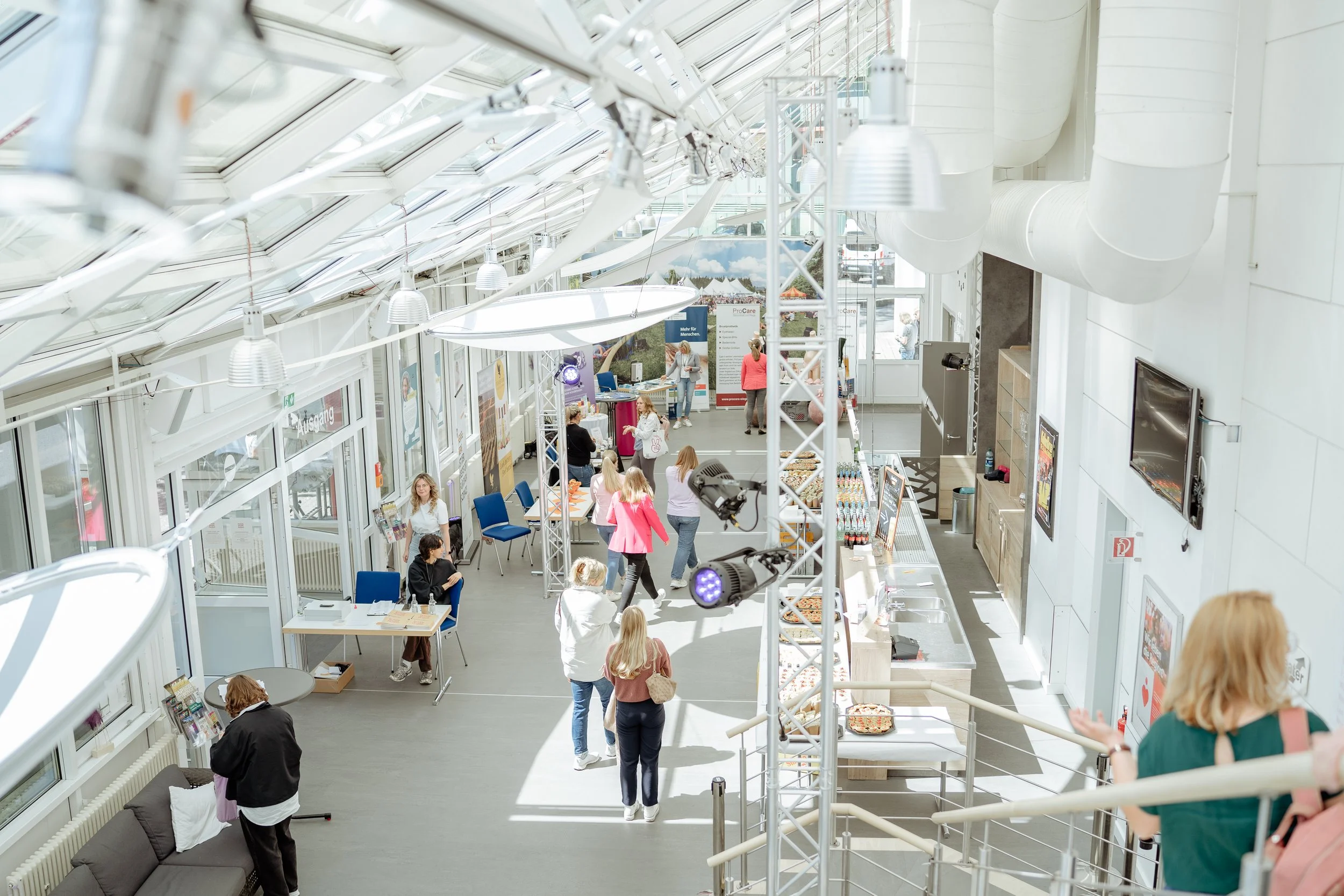 Bild Vogelperspektive in den lichtdurchfluteten verglasten Ausstellerbereich des Female Health Festivals.