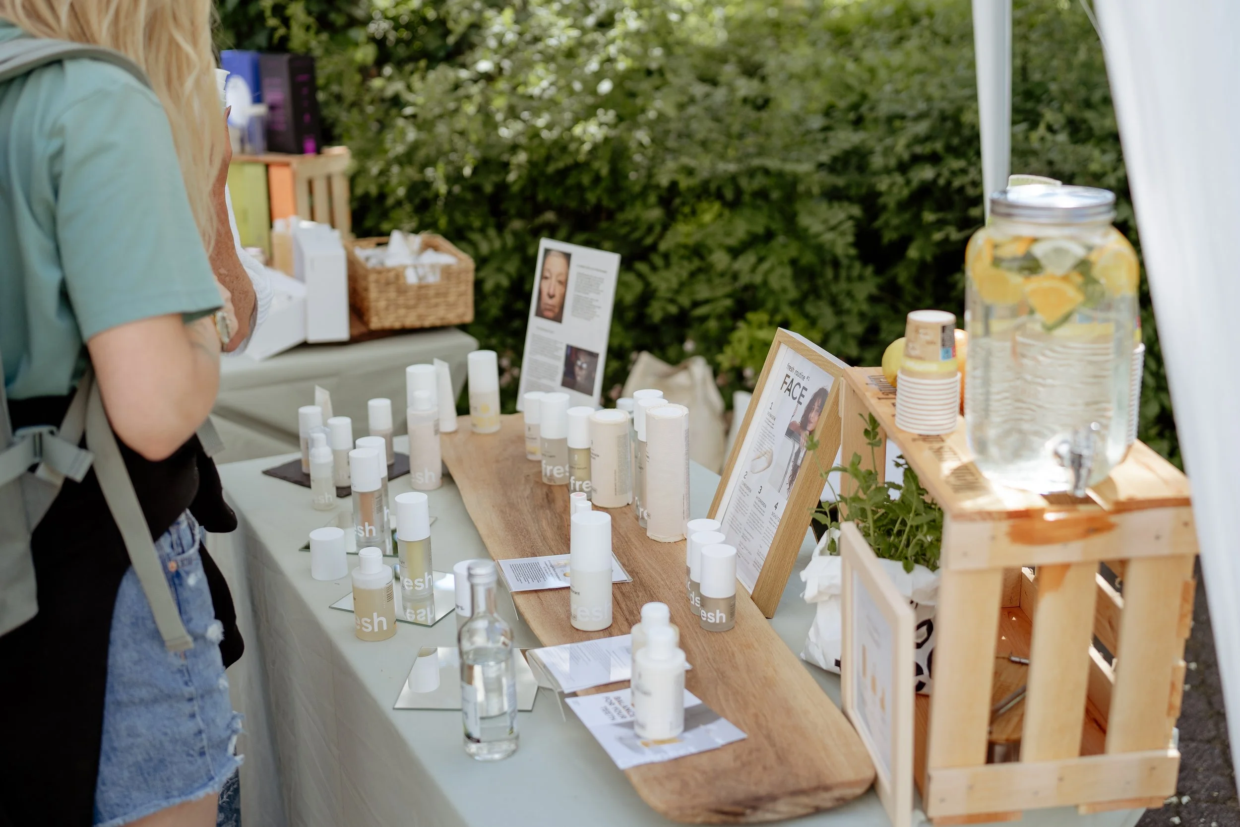 Tisch mit Getränken und Produktproben im Grünen