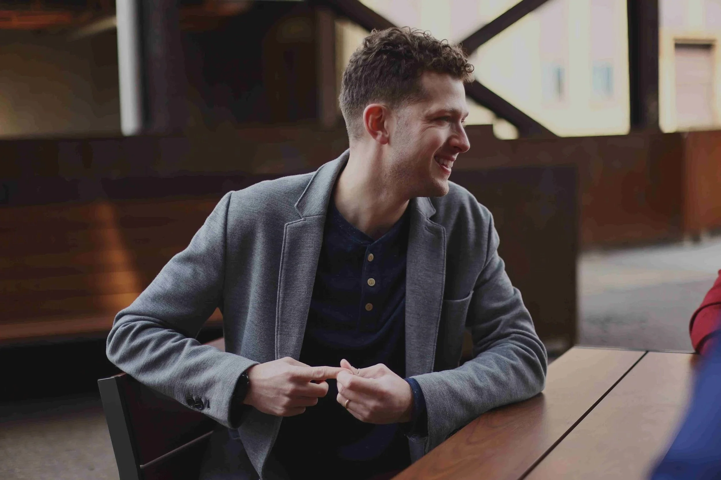 Gio wears a grey sweater suit coat