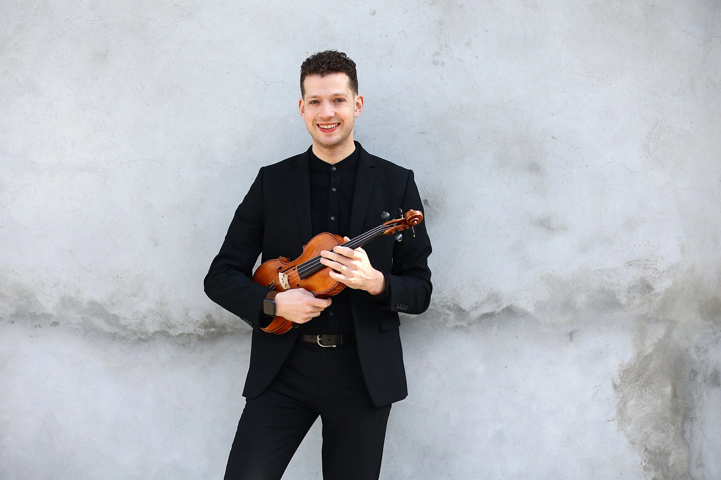 Gio stands at the white wall