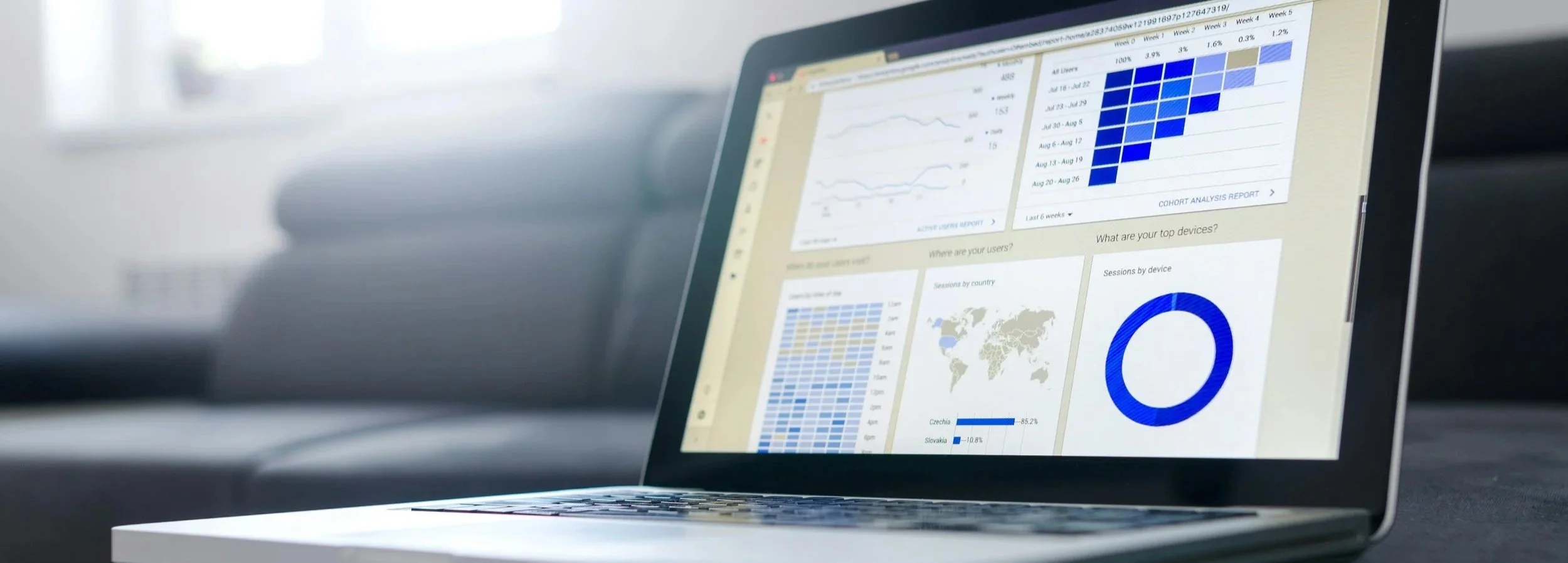 Laptop displaying analytics and data charts, including graphs, maps, and pie charts.