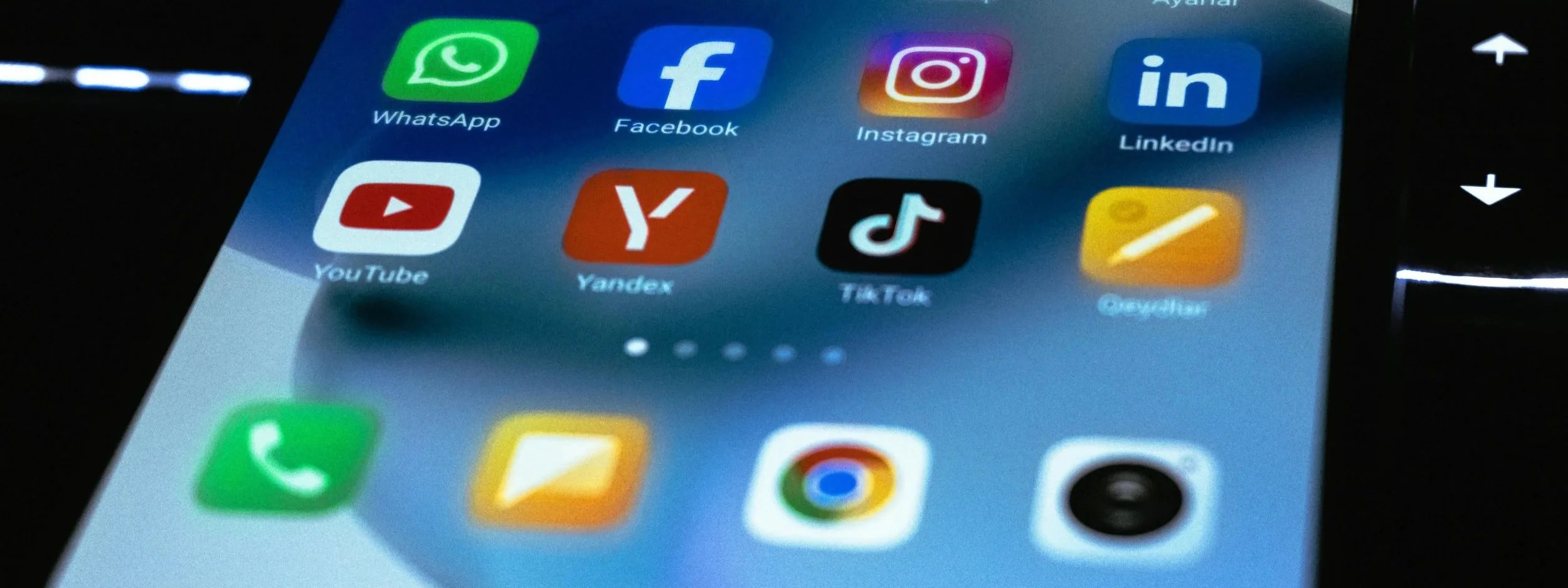 Close-up of a smartphone screen displaying various app icons including WhatsApp, Facebook, Instagram, LinkedIn, YouTube, Yandex, TikTok, and others.