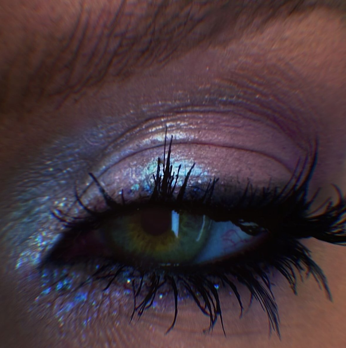 Close-up of a human eye with detailed eyelashes, iris, and surrounding skin, showing vibrant colors and textures.