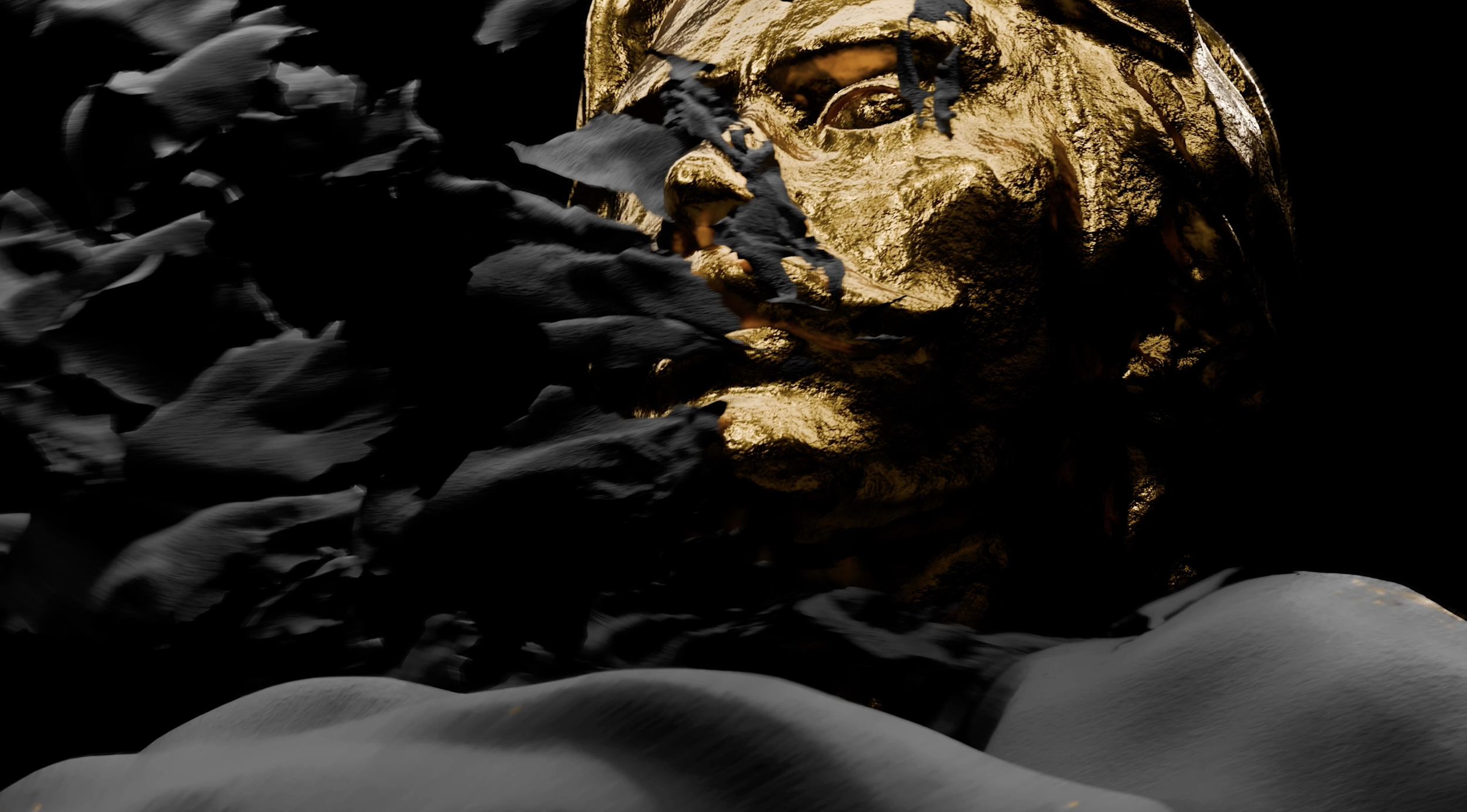 Close-up of a golden head sculpture surrounded by black leaves, with snow in the foreground.