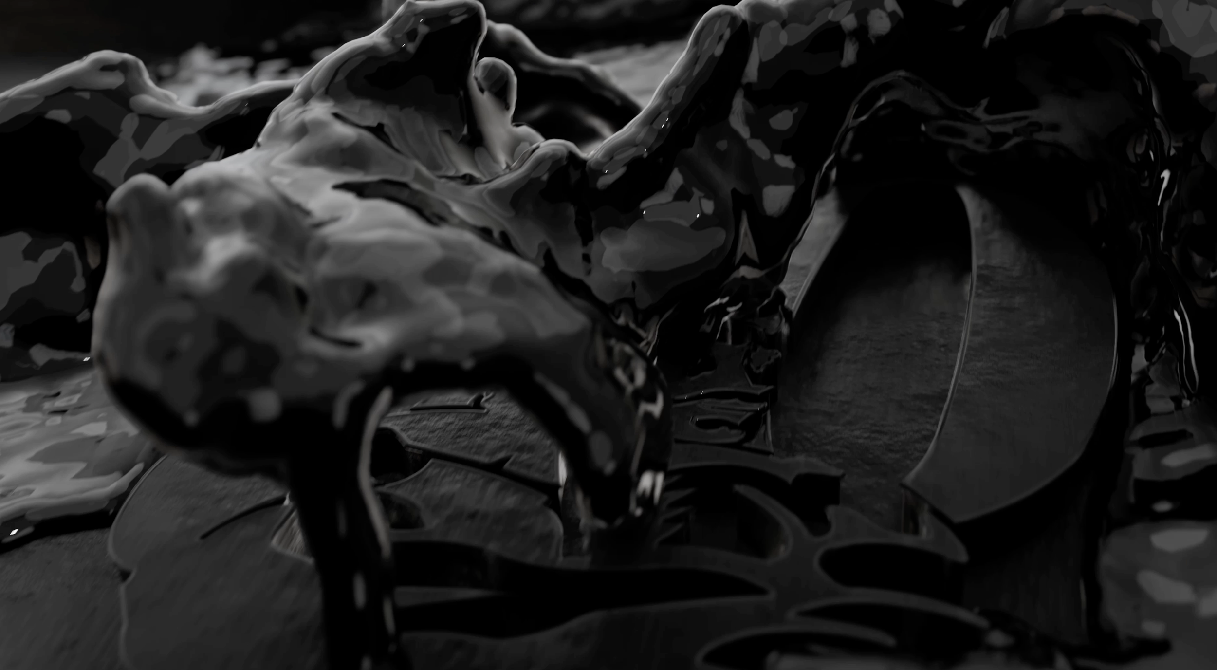 Close-up of a black metal object with intricate, abstract design and a shiny surface.