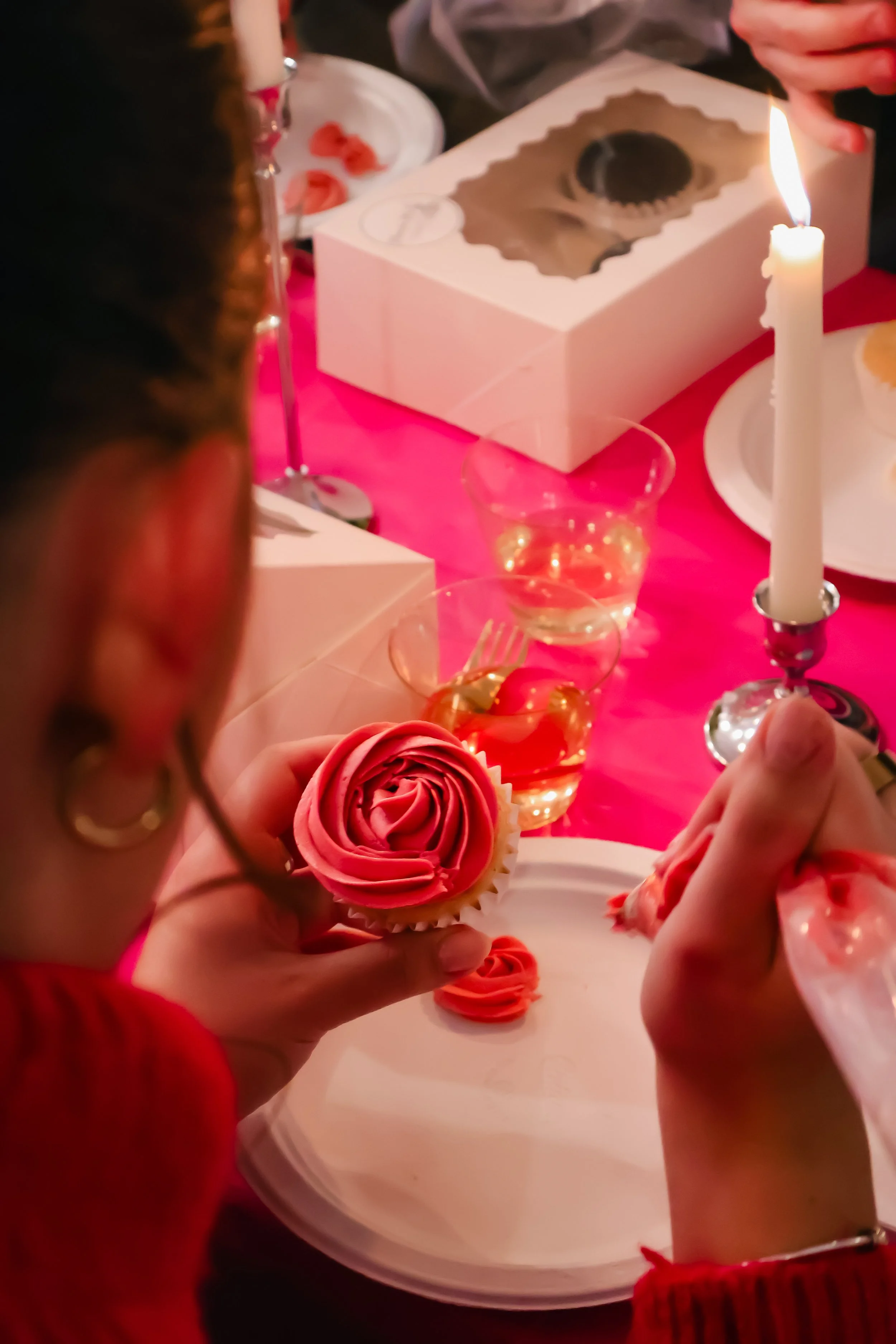 Hands decorating gluten free cupcakes at event