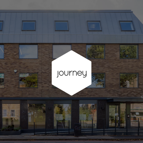 Building with reflective windows and a sign reading 'journey' in the center.