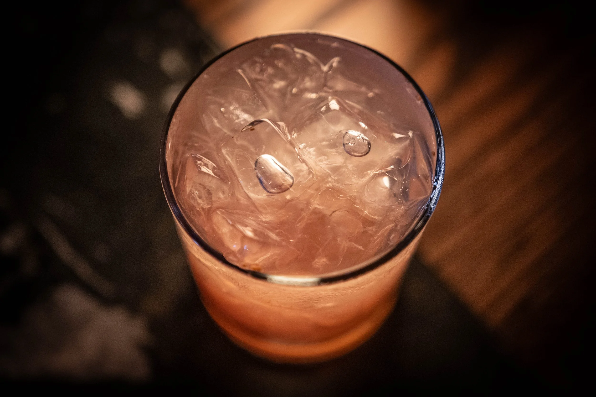 A seasonal cocktail drink sits on a counter in a glass cup
