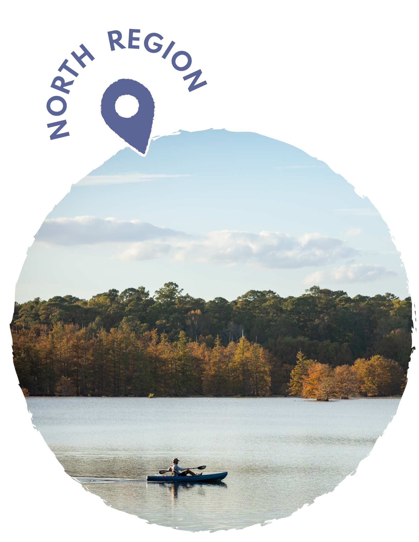 Person kayaking on a lake surrounded by trees with autumn foliage, under a partly cloudy sky.