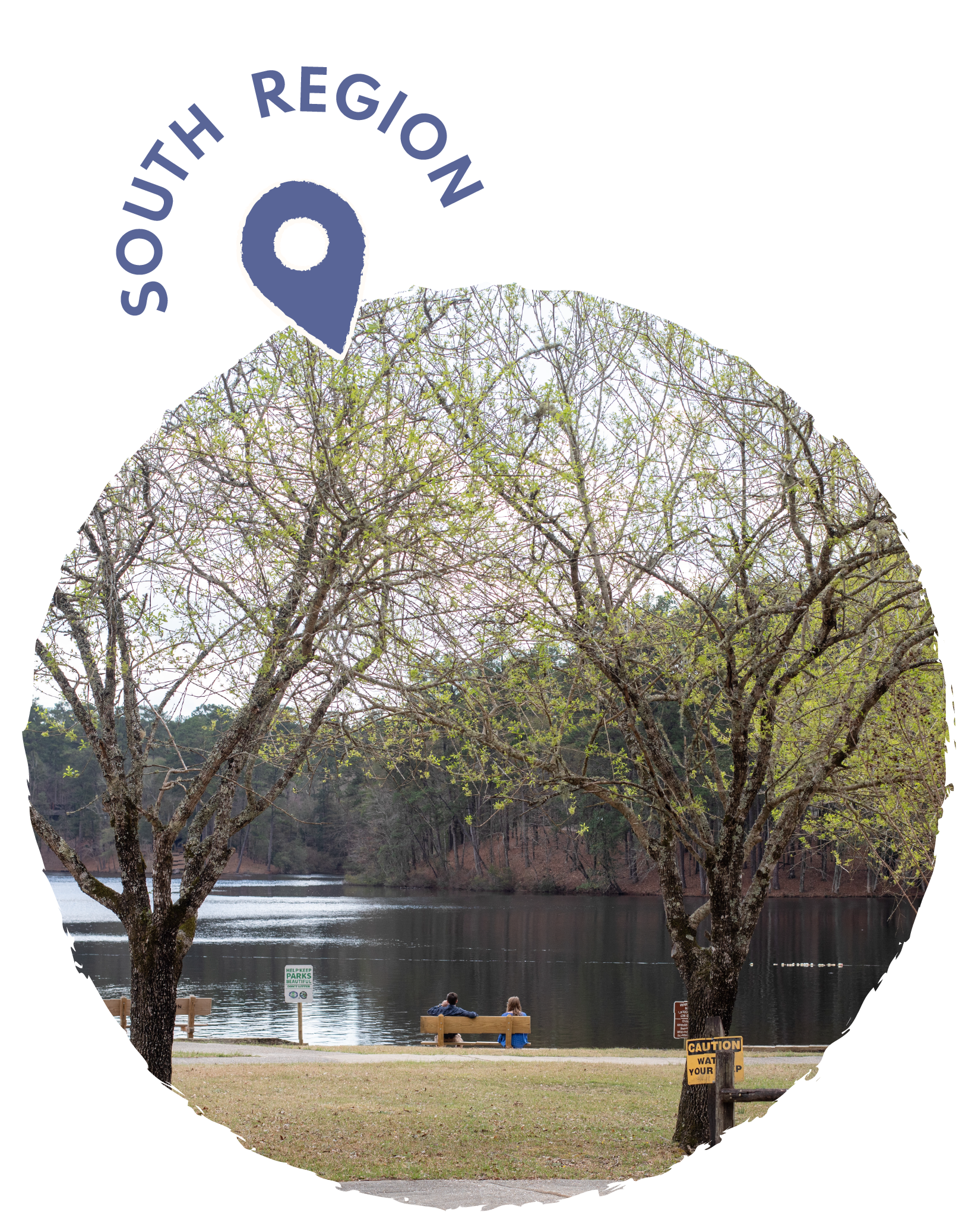 Two people sitting on a park bench near a river with trees and caution signs visible.