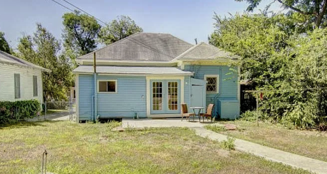 Blue house with patio and outdoor furniture in backyard