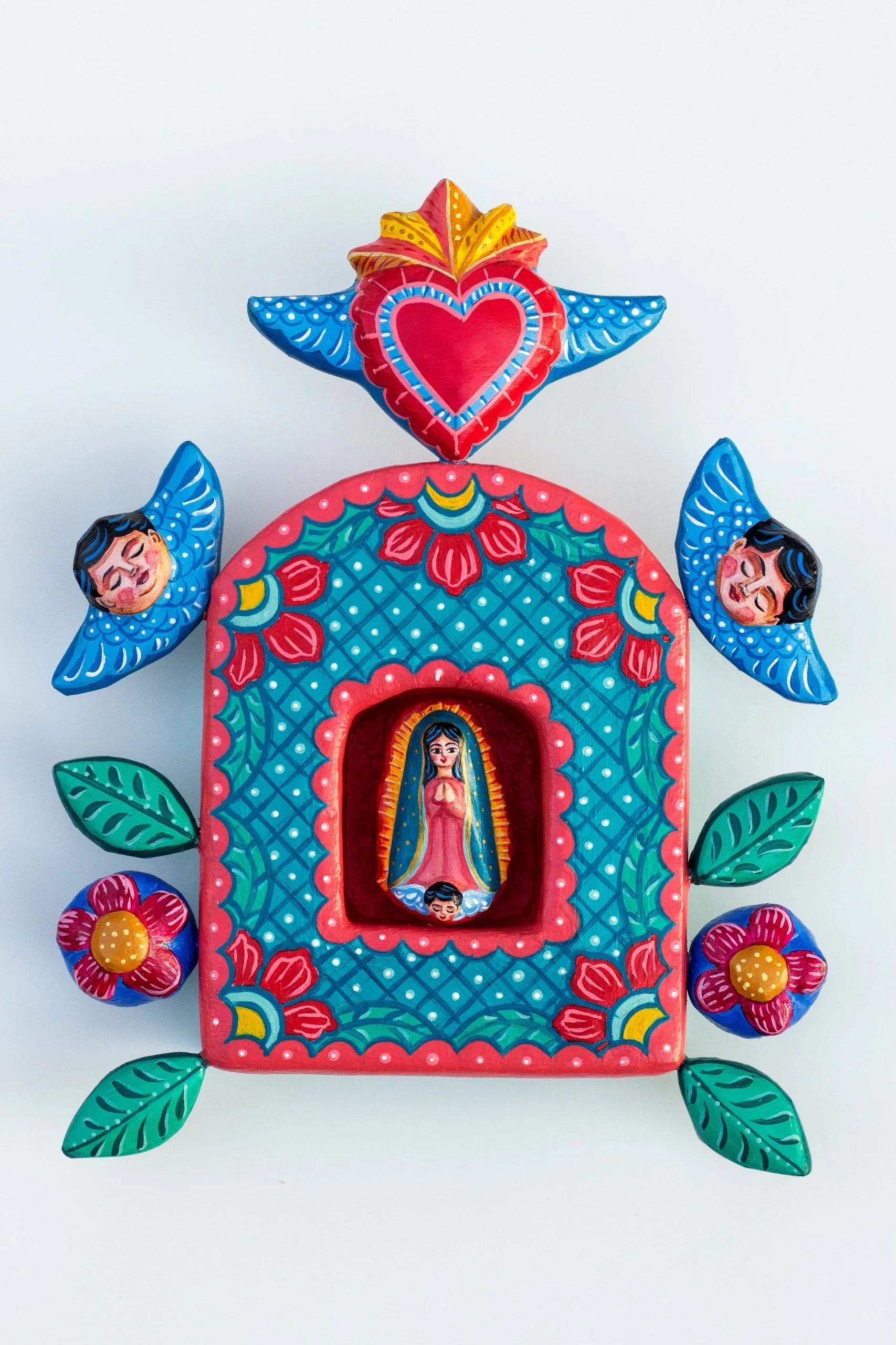 Colorful Mexican-style decorative artwork featuring a central Virgin Mary figure, surrounded by flowers and leaves, with a large heart and star at the top, painted in bright colors.