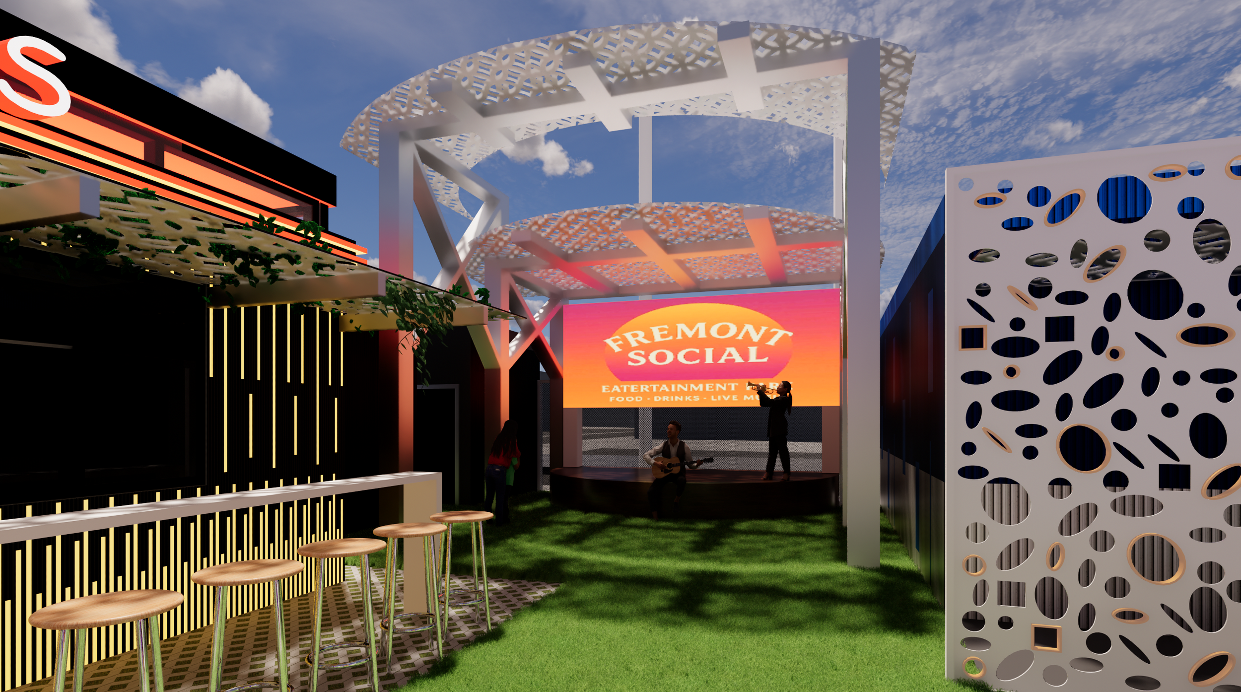 Outdoor entertainment area with a stage featuring a large screen displaying 'Fremont Social' with additional text about food, drinks, and live music. The stage has a decorative white pergola. To the left, there is a bar counter with barstools, and to the right, decorative white panels with circular cutouts. The ground is covered with grass, and the area is under a partly cloudy sky.